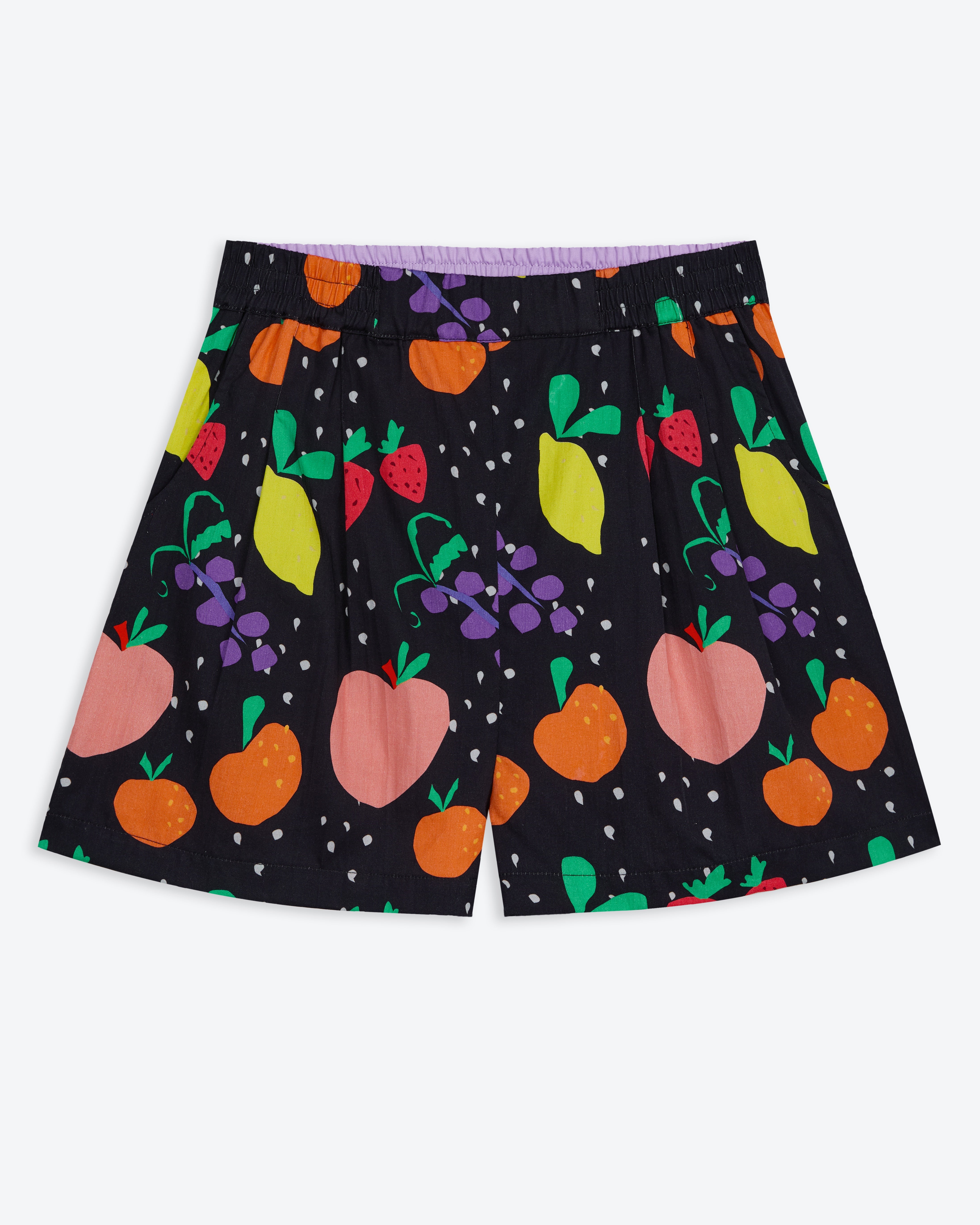 A pair of Miss Pompom holiday shorts with a tropical fruit print in bright colors on a black background, featuring an elastic waistband and side pockets.