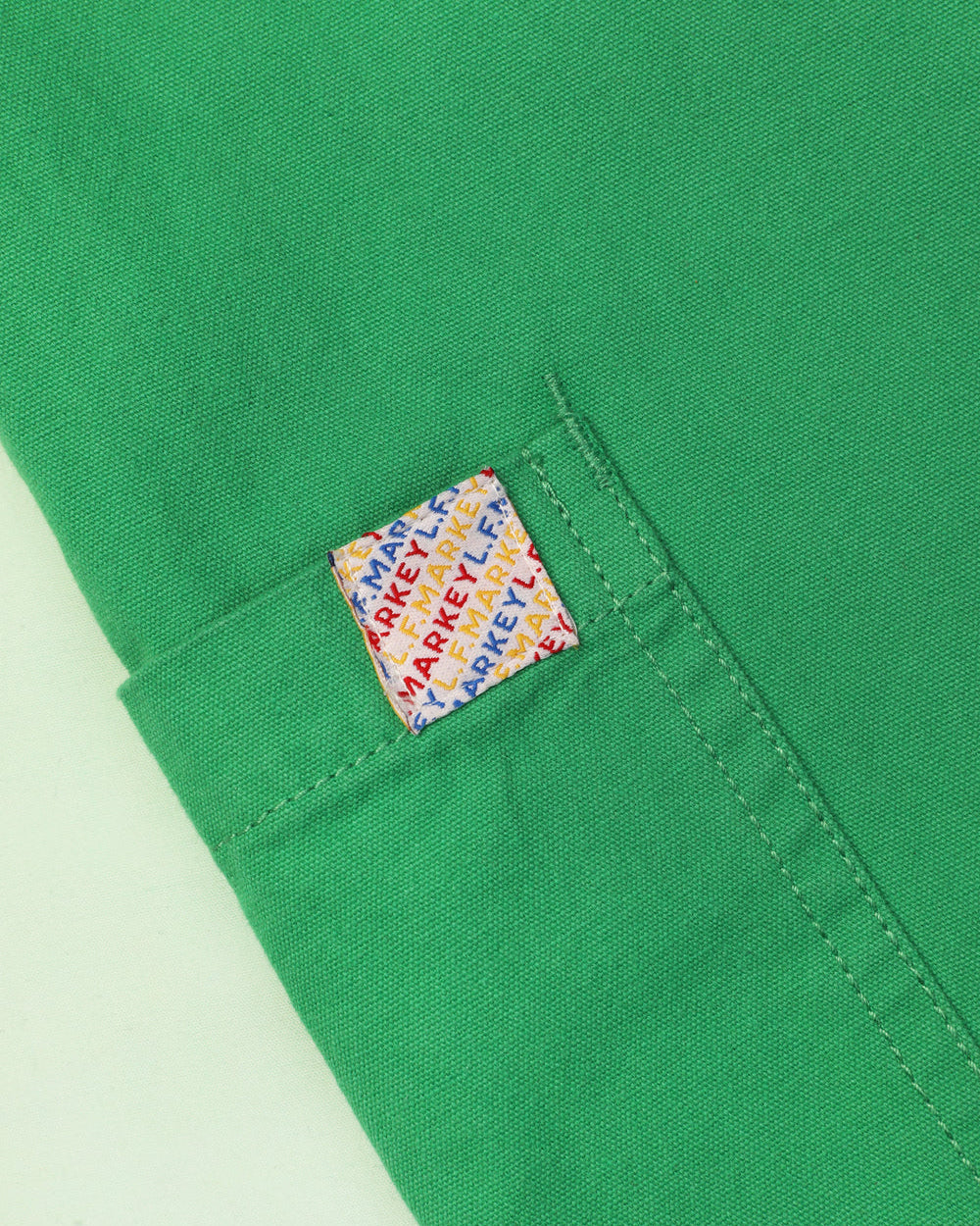 A pair of green cotton workwear style trousers with high elasticated waist and utility style pocket detailing.