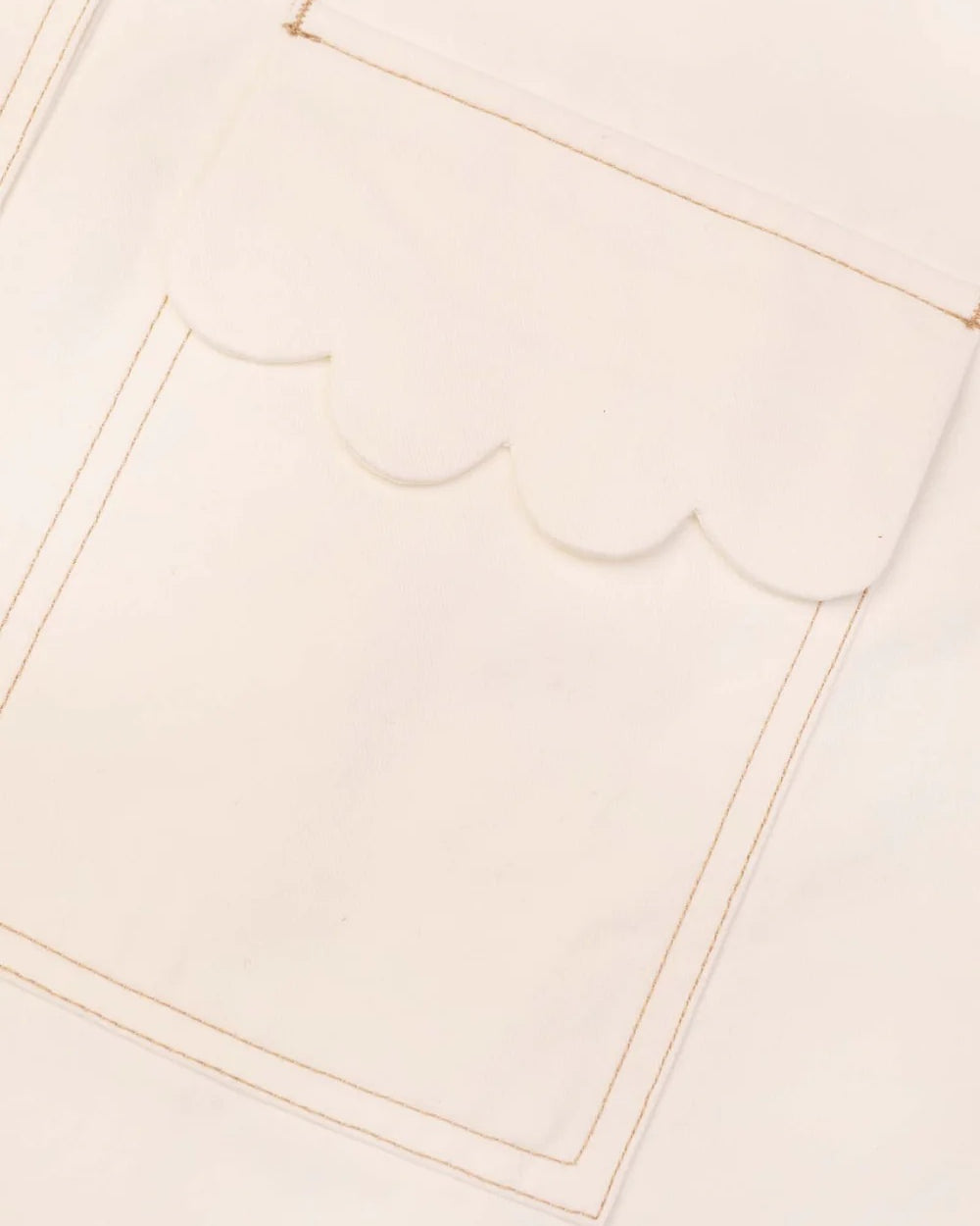 Close-up of a beige fabric with scalloped edge trim