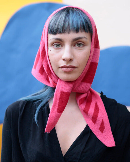 Woman wearing a pink headscarf with a colorful abstract background