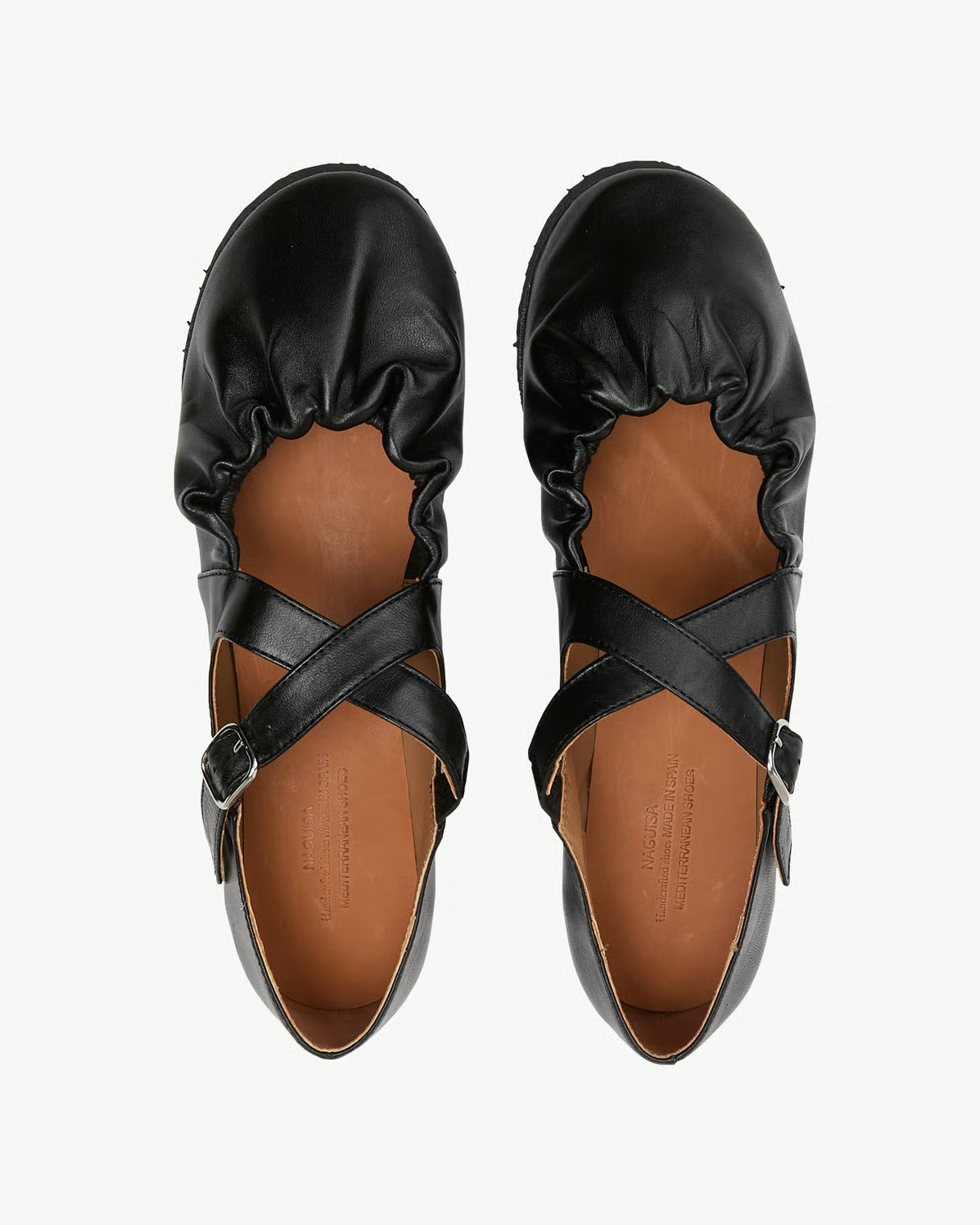 Pair of anguish black cross strap flats on a white background