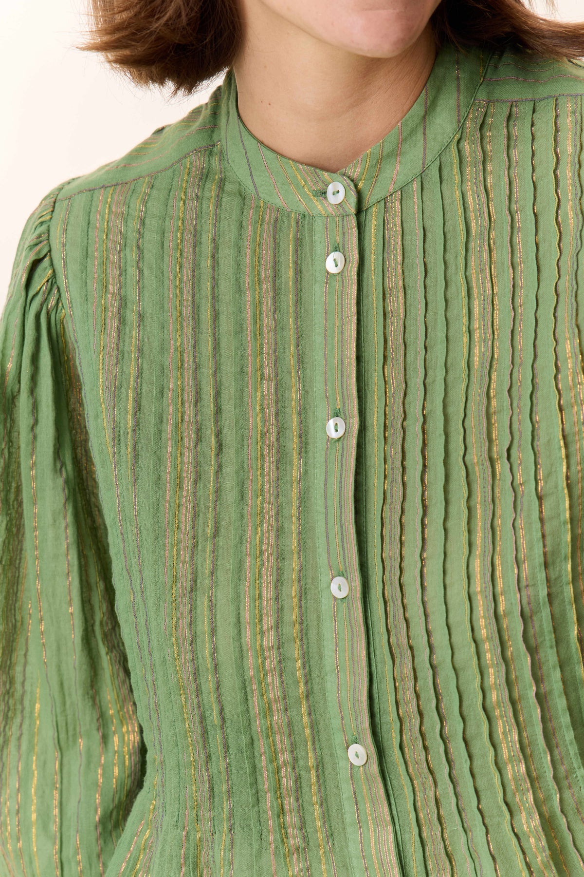 Close-up of a green striped shirt with buttons