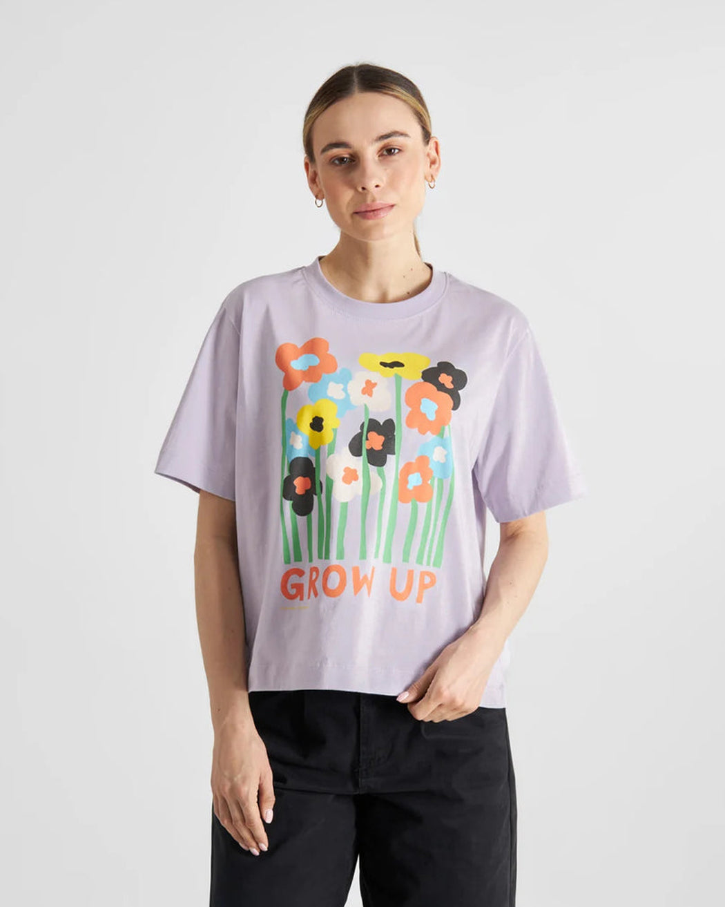 A relaxed fit purple T-shirt with a graphic of flowers and the text 'GROW UP' designed by Luke John Arnold.