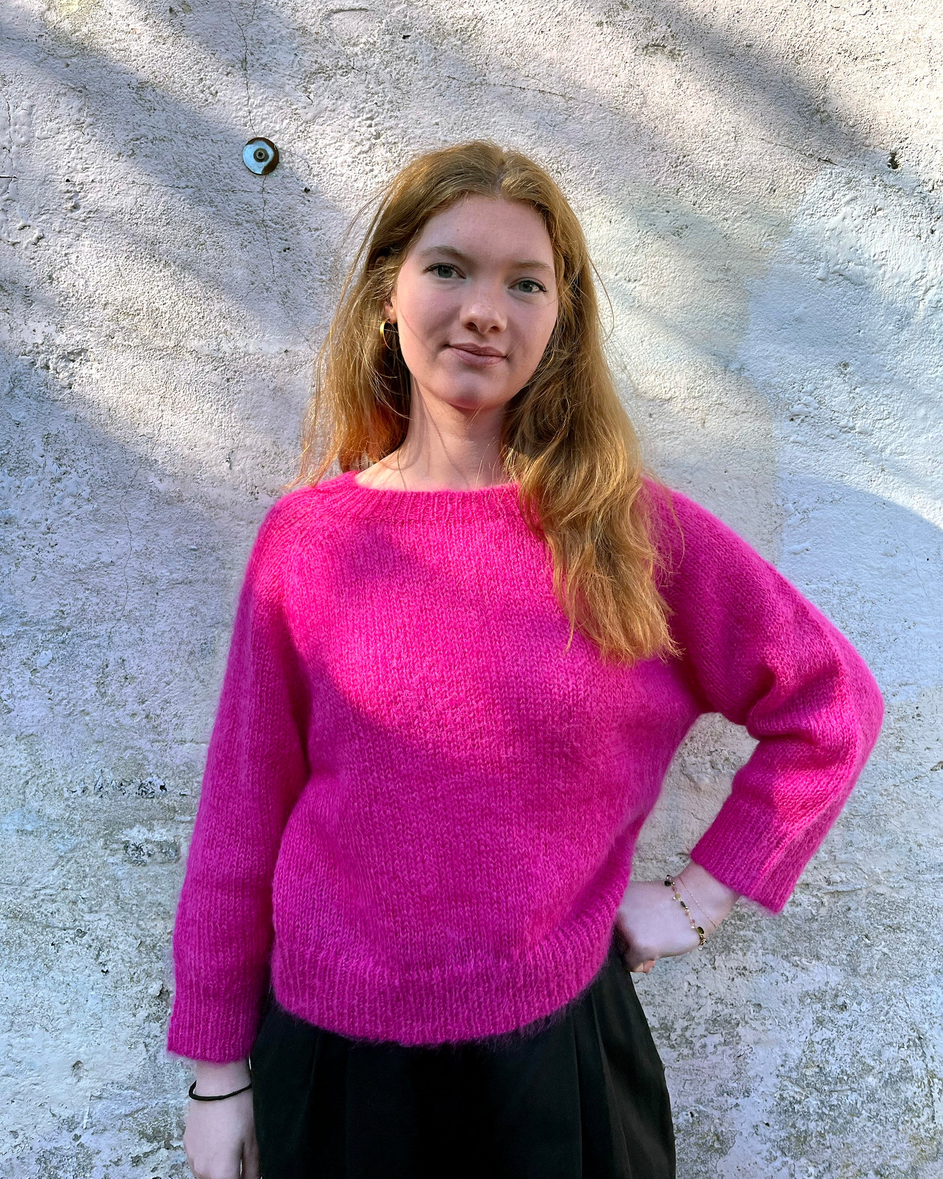 Person wearing bright pink mohair jumper