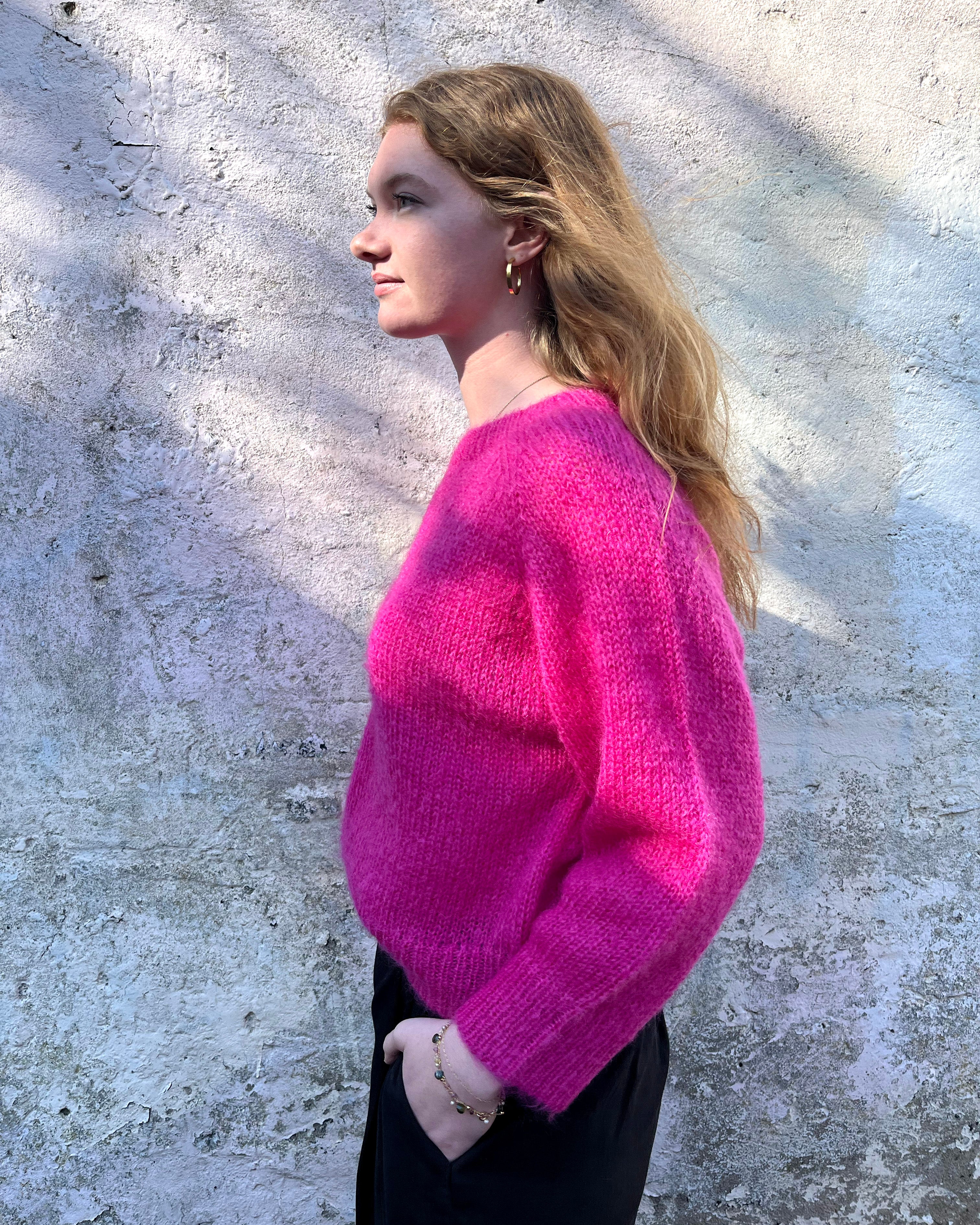 Person wearing bright pink mohair jumper