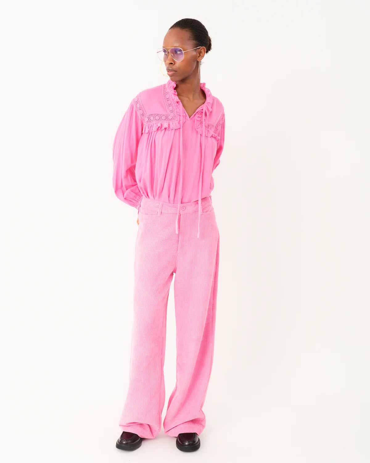 Person wearing a pink jumpsuit on a white background