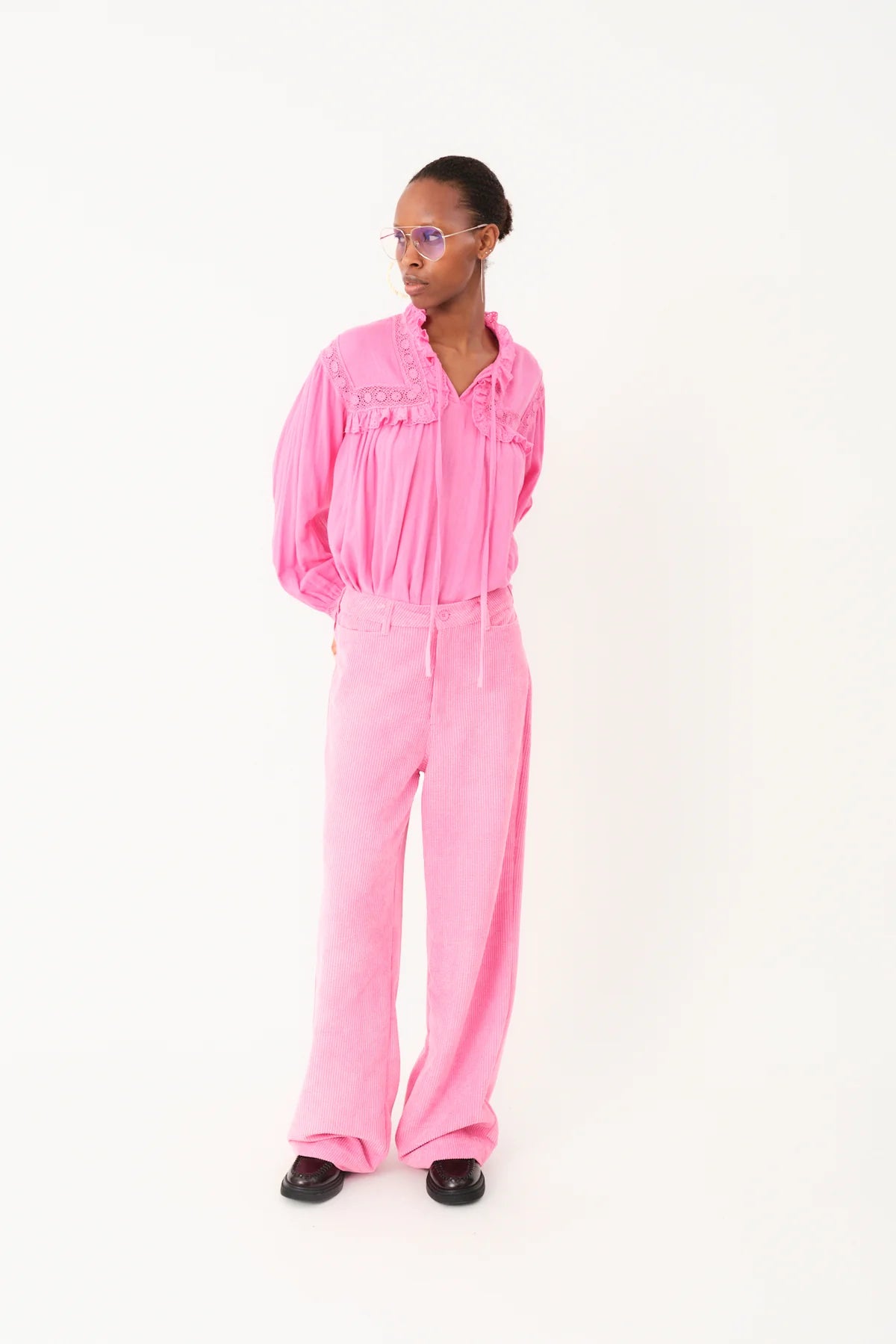 Person wearing a pink jumpsuit on a white background