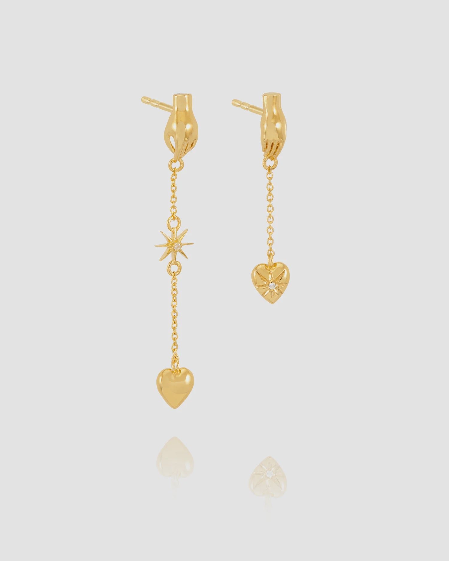 Gold heart-shaped earrings on a light gray background