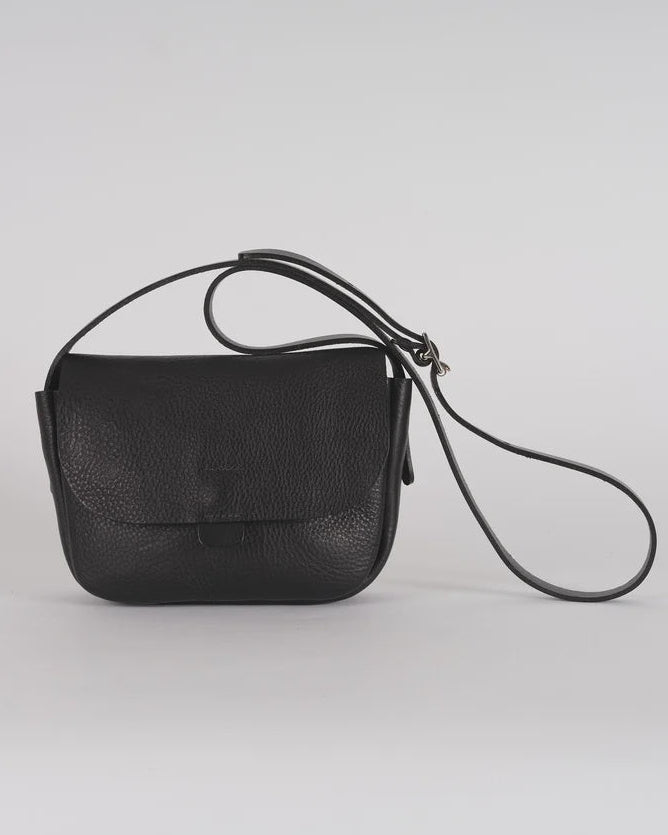 Black leather handbag with a strap on a light gray background