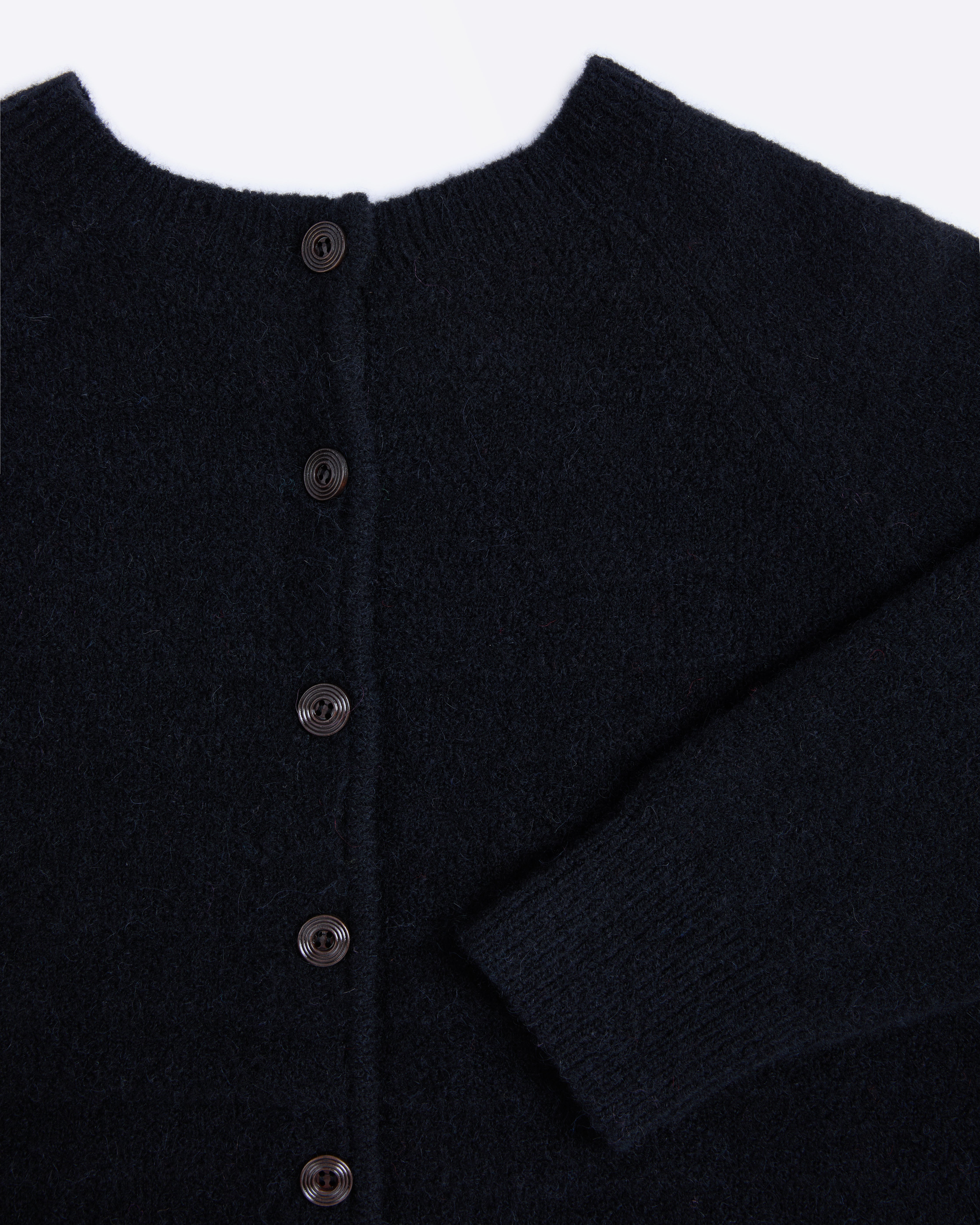 Close-up of a dark blue cardigan with buttons on a white background