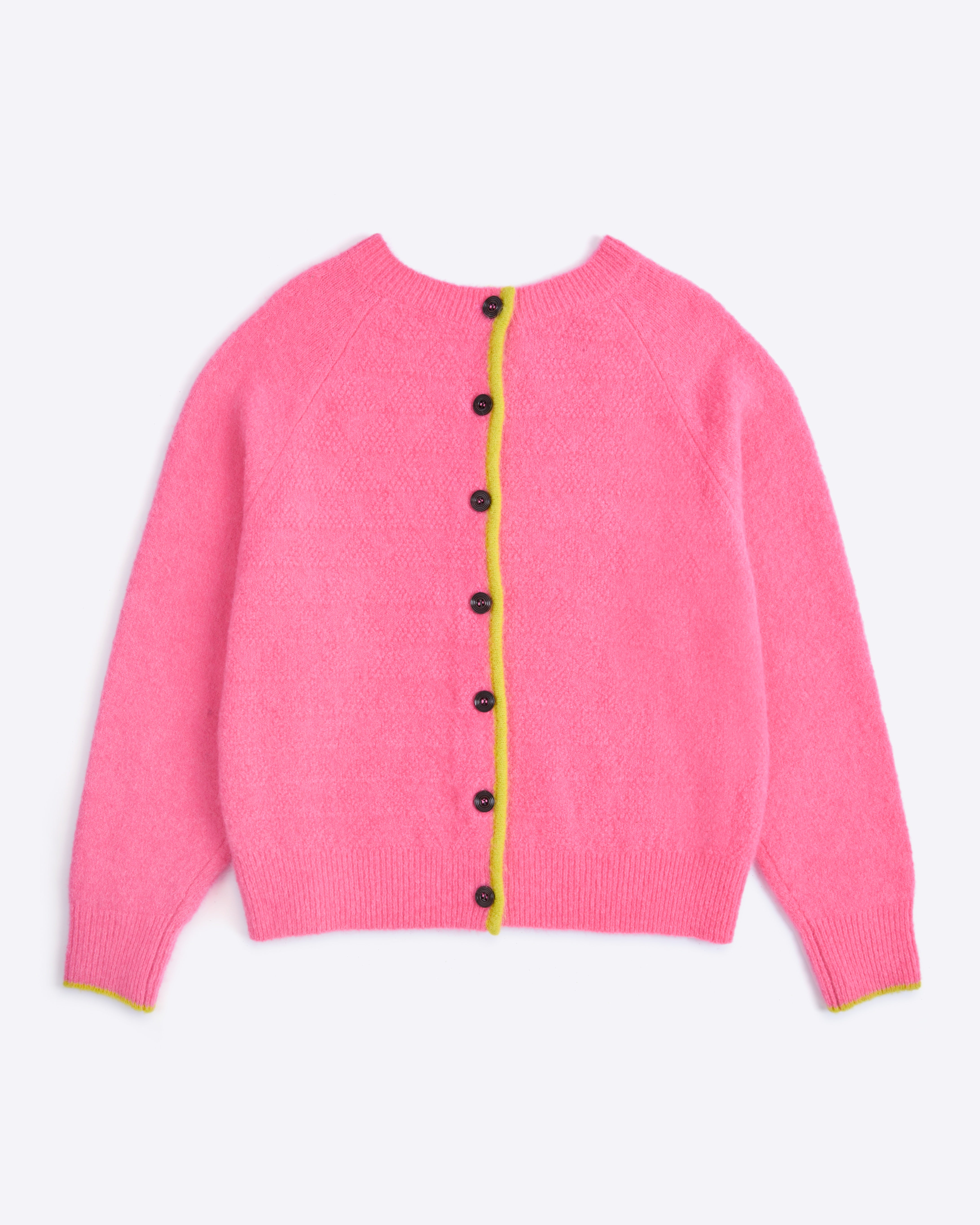 Pink cardigan with black buttons on a light purple background