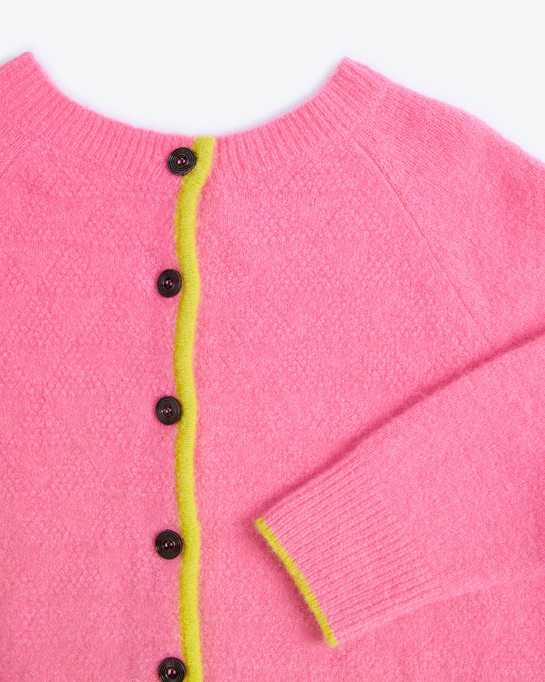 Close-up of a pink cardigan with black buttons and yellow trim on a white background
