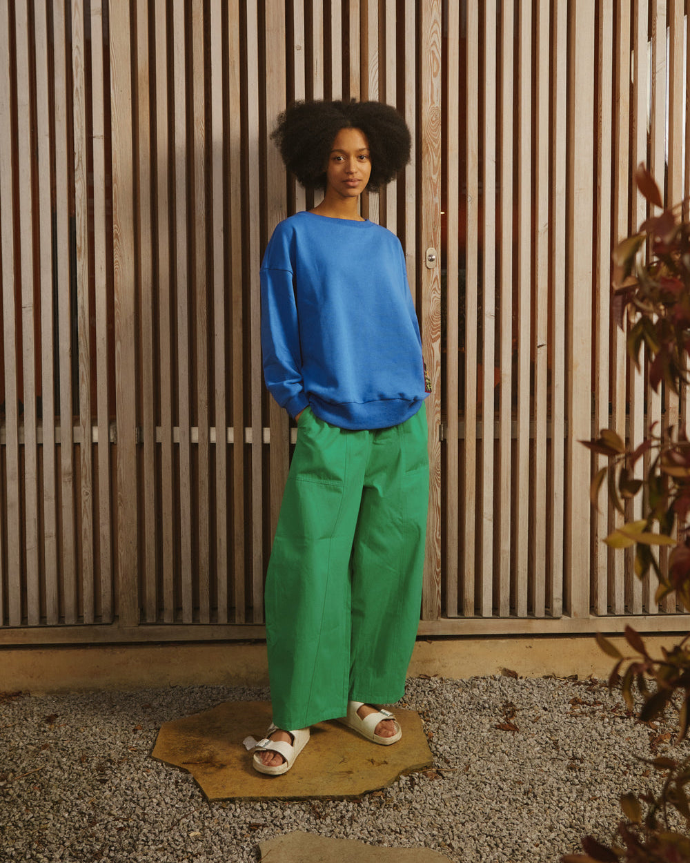 A pair of green cotton workwear style trousers with high elasticated waist and utility style pocket detailing.