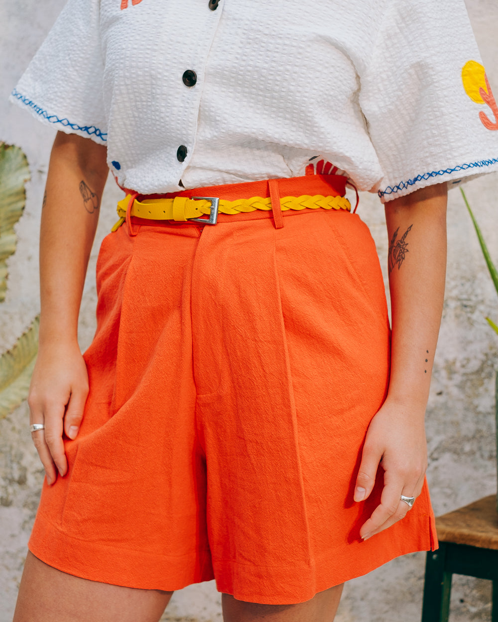 A pair of high-waisted, mid-length, tailored tomato shorts made from a cotton and linen mix.