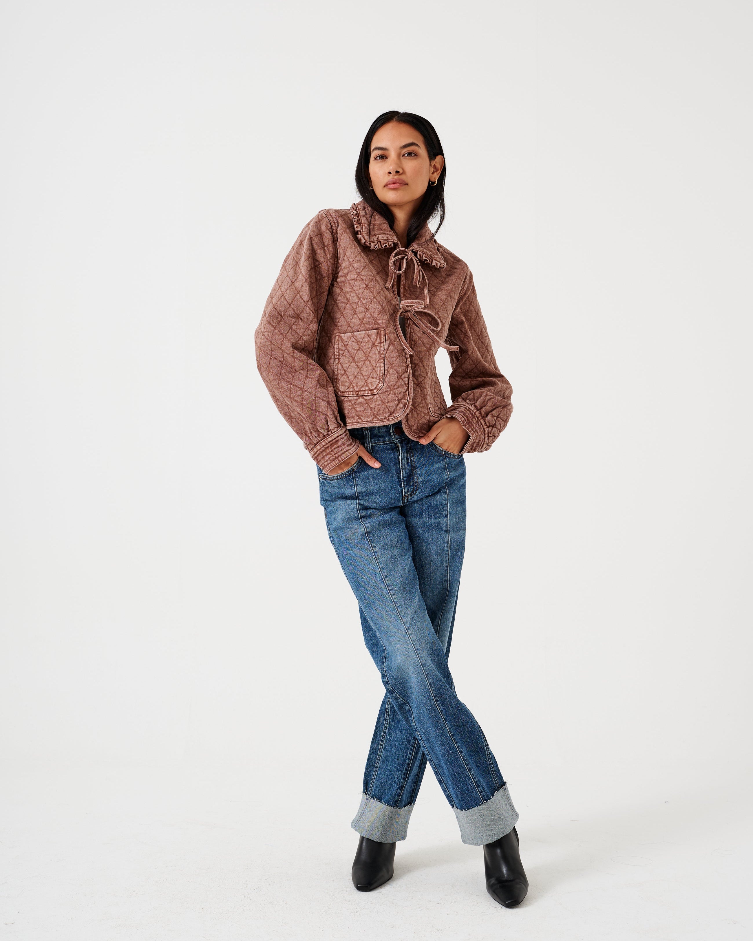 A pair of blue denim jeans with a frayed hem and a deep turn-up at the cuffs, featuring a straight leg cut and mid-rise waist.