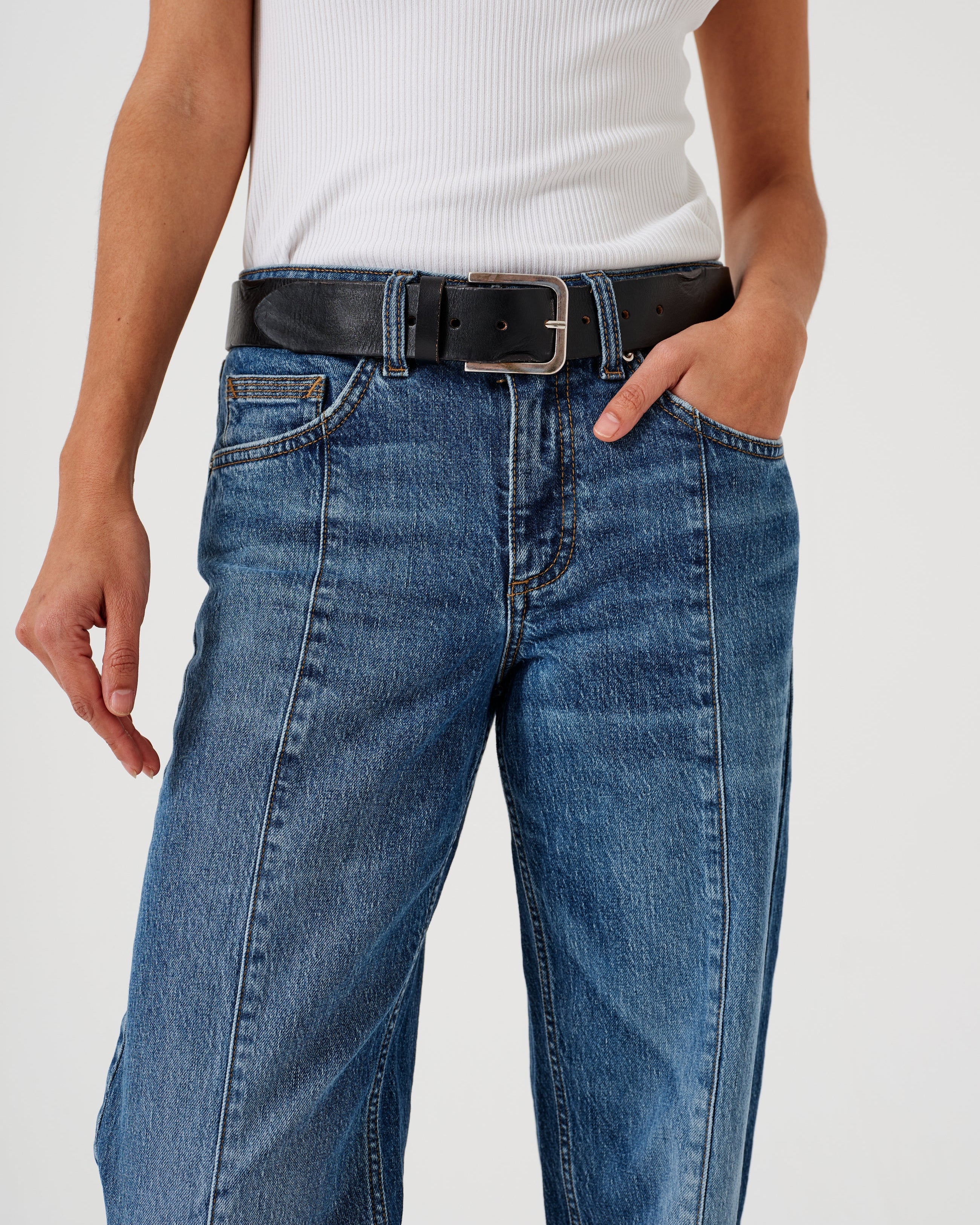 A pair of blue denim jeans with a frayed hem and a deep turn-up at the cuffs, featuring a straight leg cut and mid-rise waist.