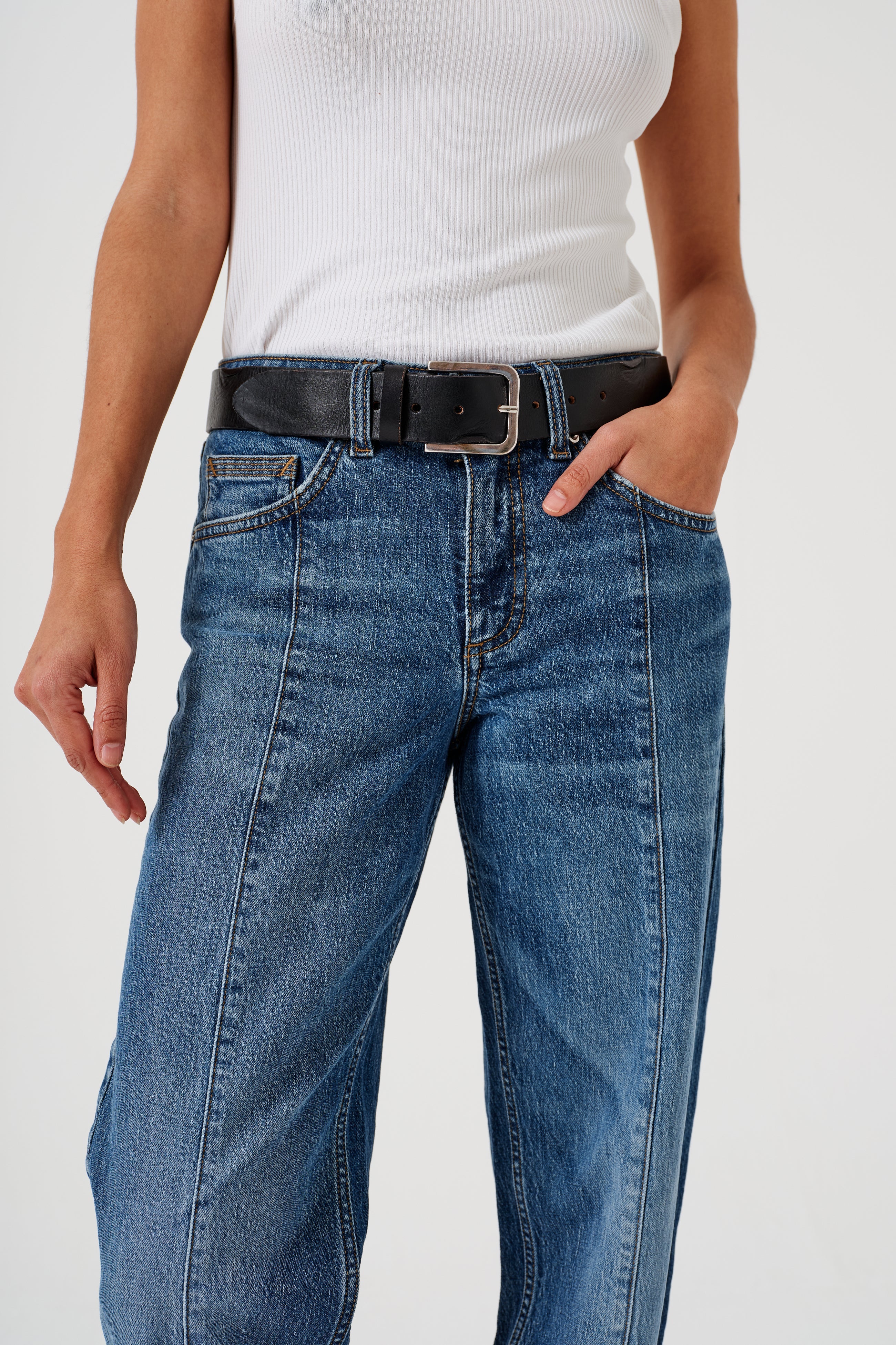 A pair of blue denim jeans with a frayed hem and a deep turn-up at the cuffs, featuring a straight leg cut and mid-rise waist.