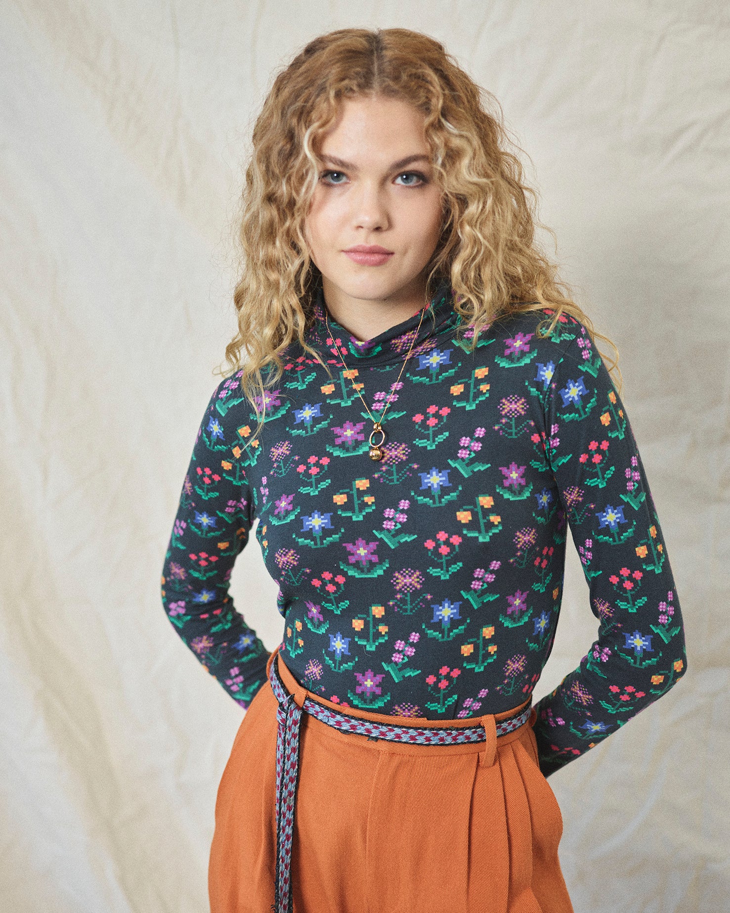 A long sleeve printed roll neck t-shirt with a turtle pattern in multicolor on a black background, made from organic cotton.