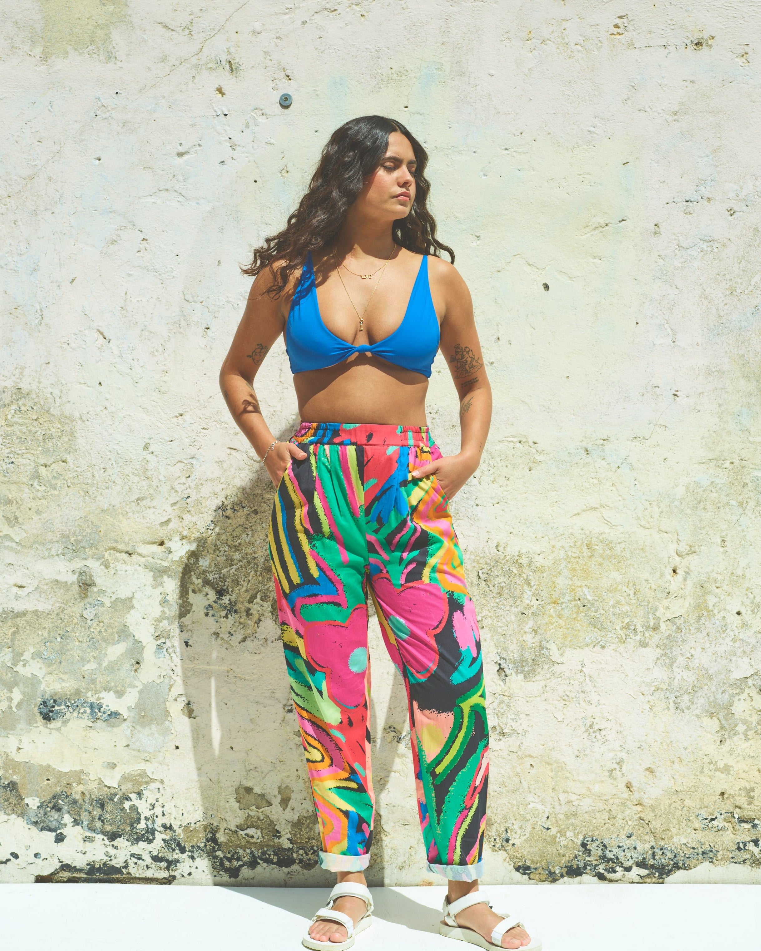 A pair of Miss Pompom Jungle Holiday Trousers with a vibrant hand-drawn tropical print in bright colors.