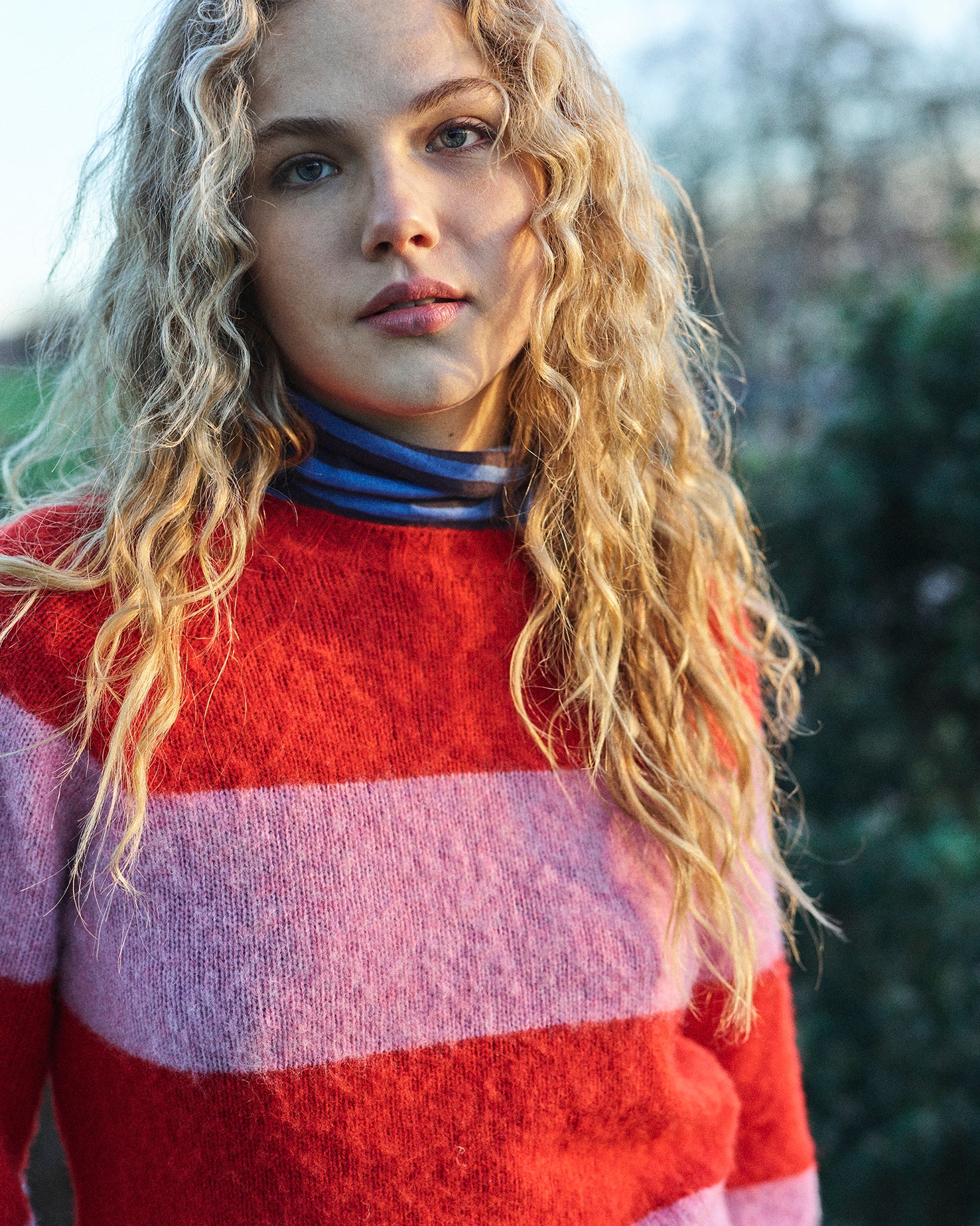 A striped Scottish jumper in pink and red with a round neckline and ribbed-knit hemline and trim around neck and wrist.