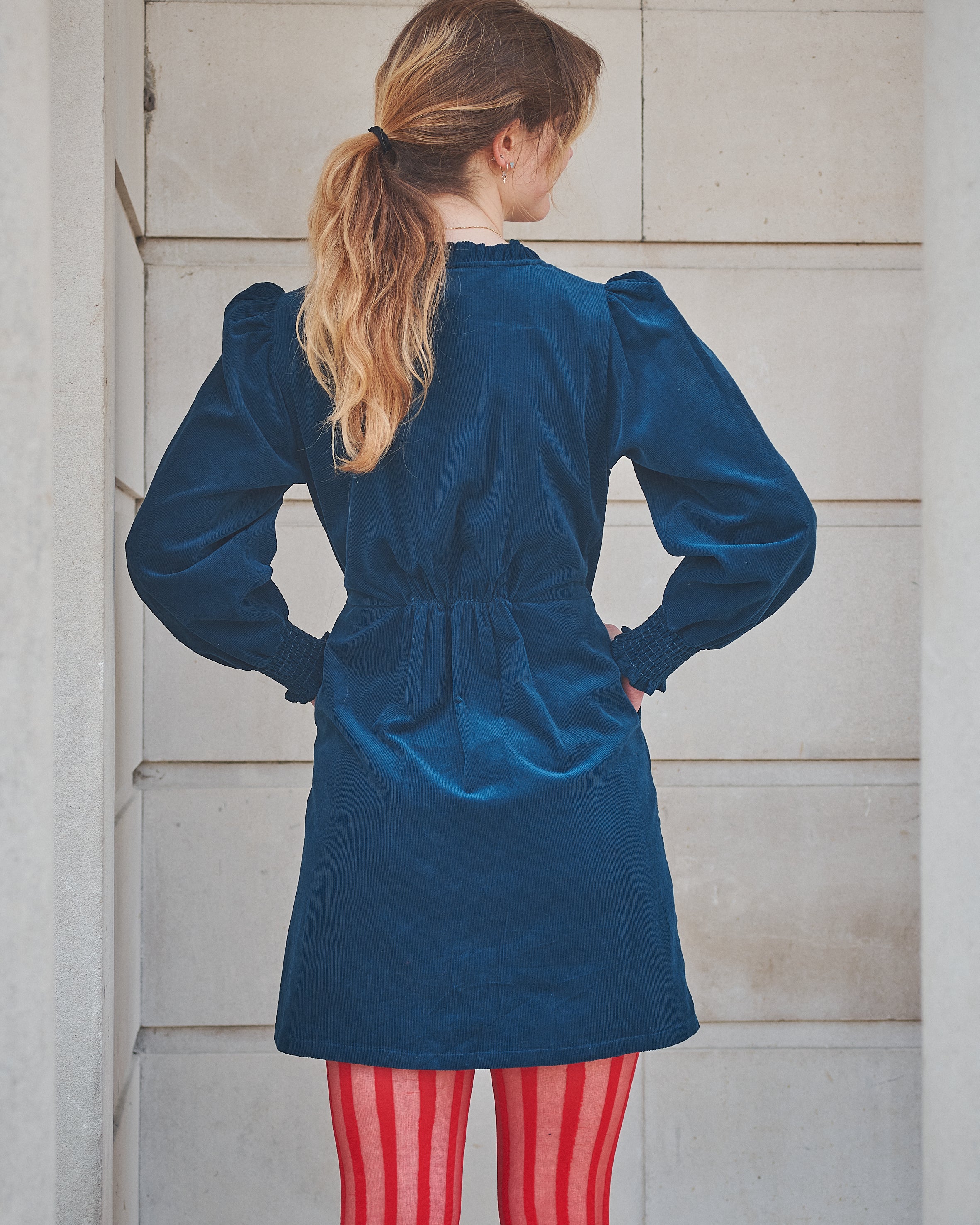 woman wearing a short navy corduroy dress
