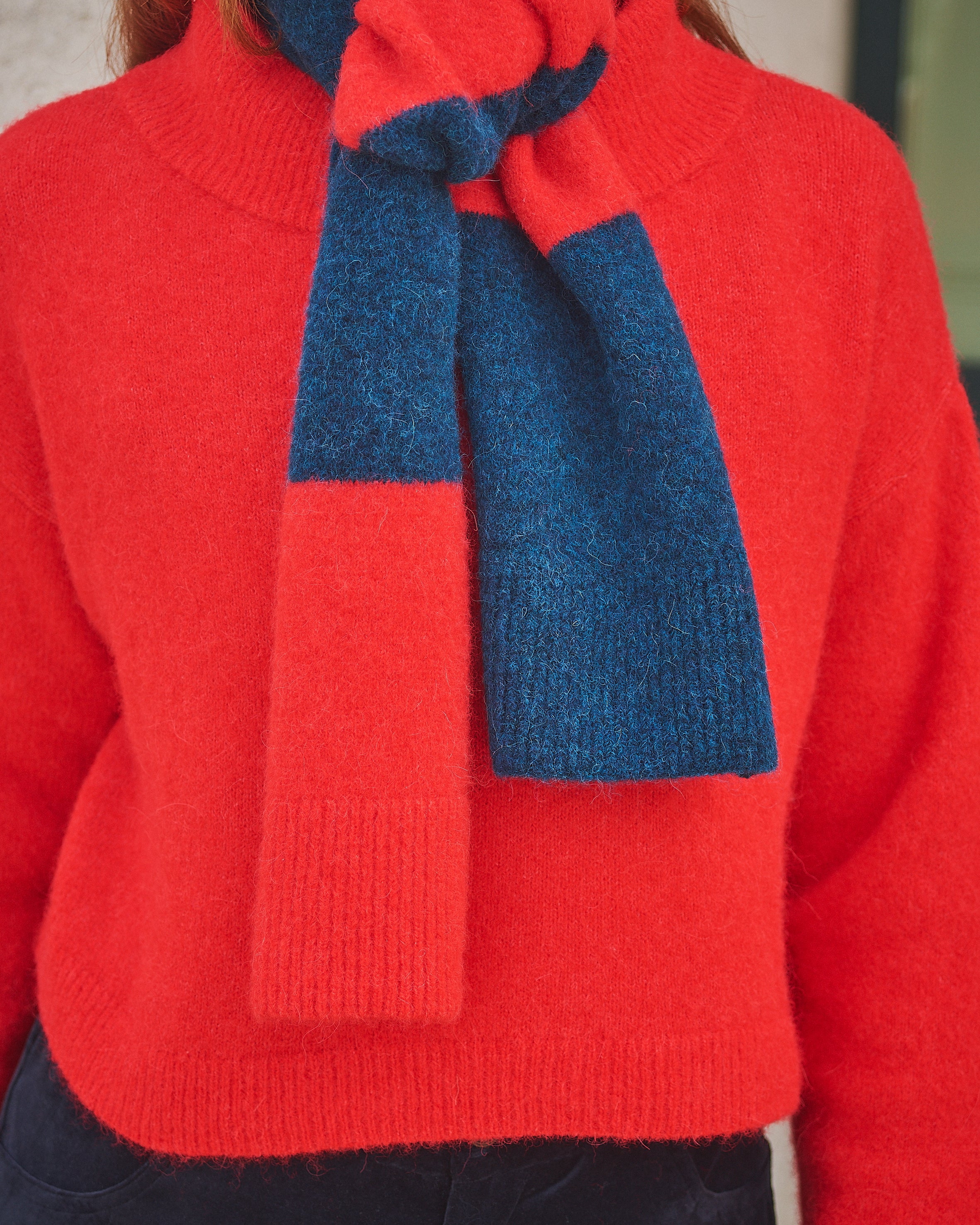Person wearing a Lowie Red/ Blue Striped scarf