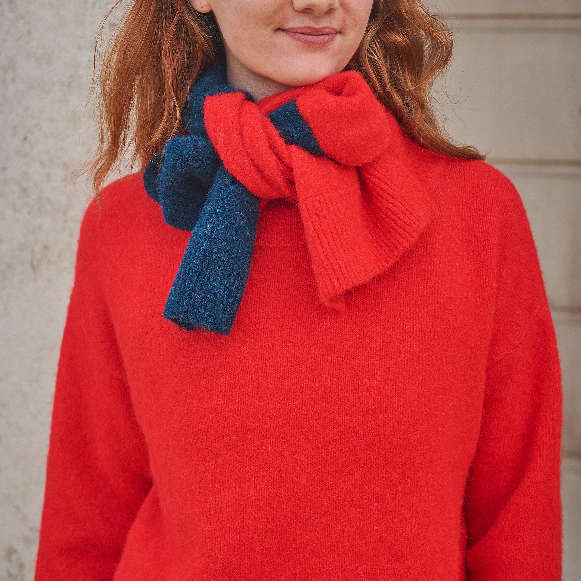 Woman wearing a striped Red/ Blue scarf