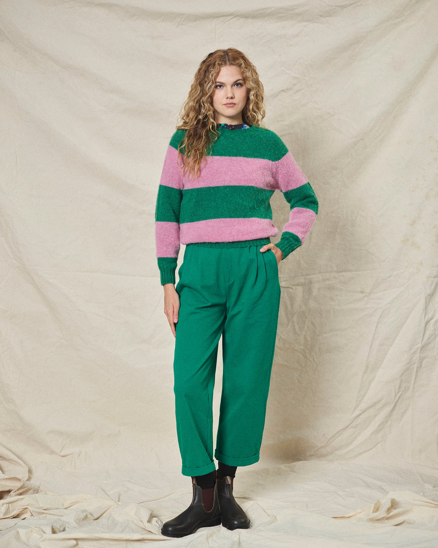 A pair of green pleat front trousers with a tab front opening and back jet pockets.