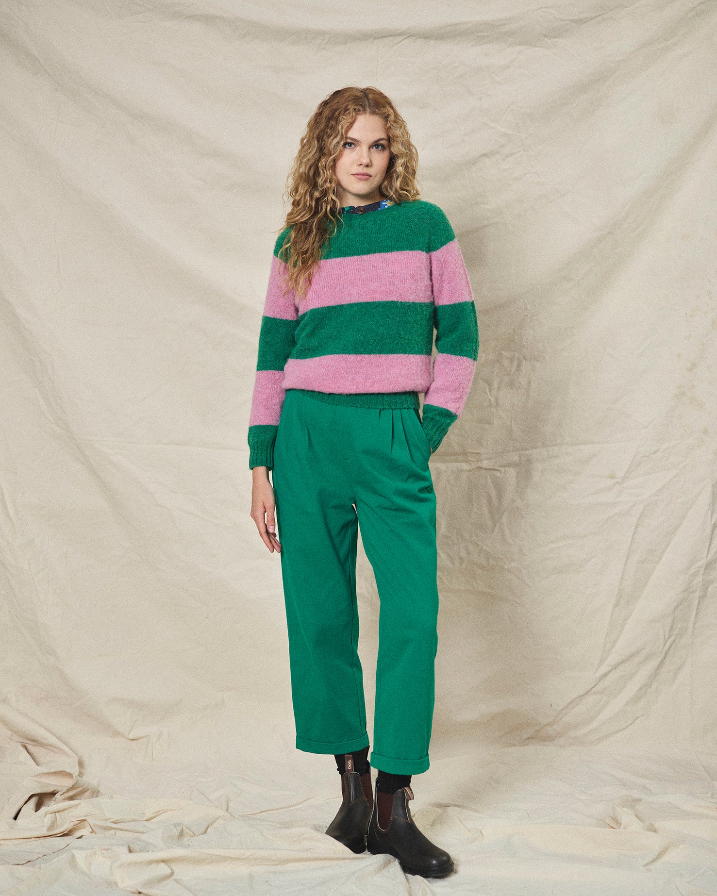 A pair of green pleat front trousers with a tab front opening and back jet pockets.