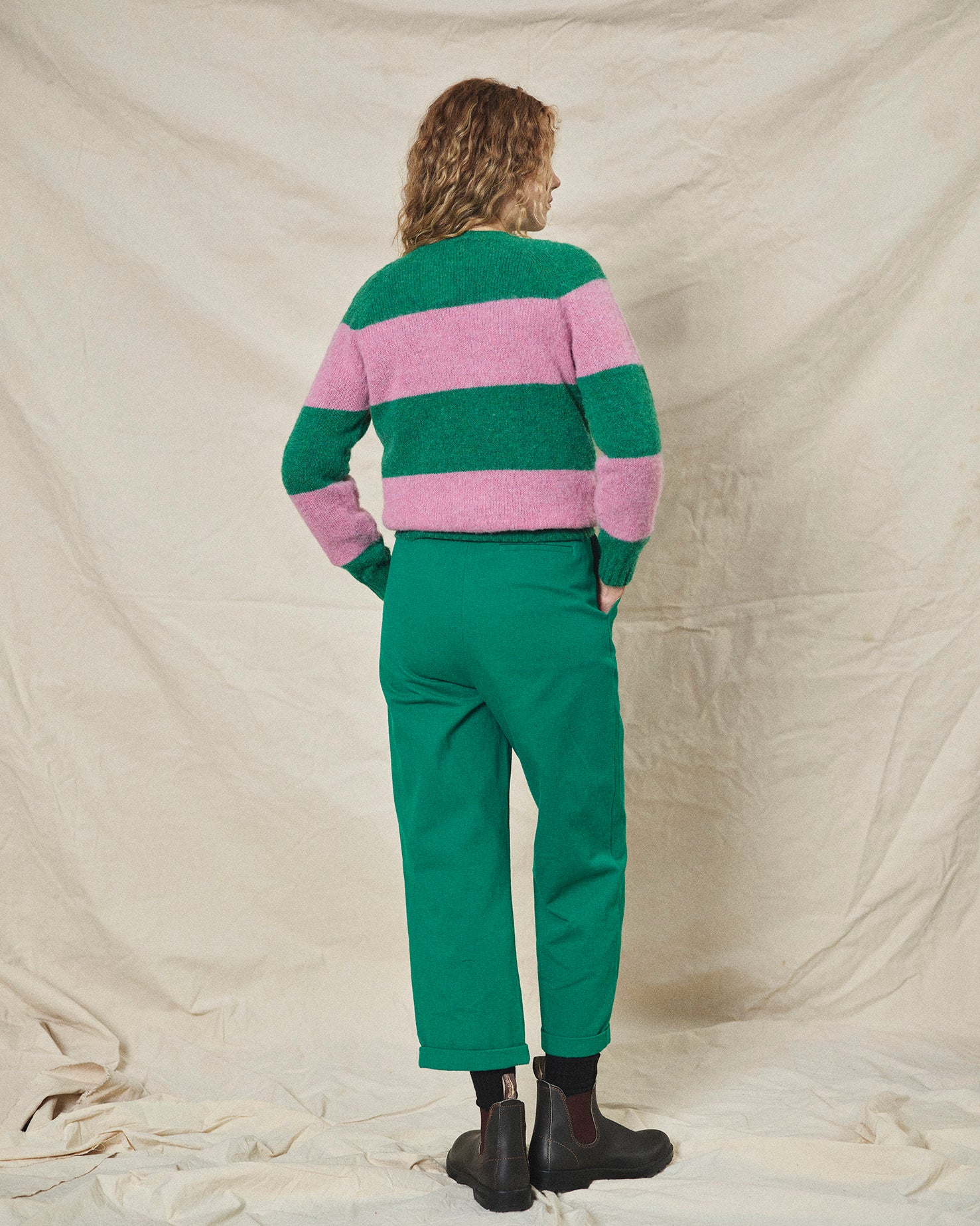 A pair of green pleat front trousers with a tab front opening and back jet pockets.