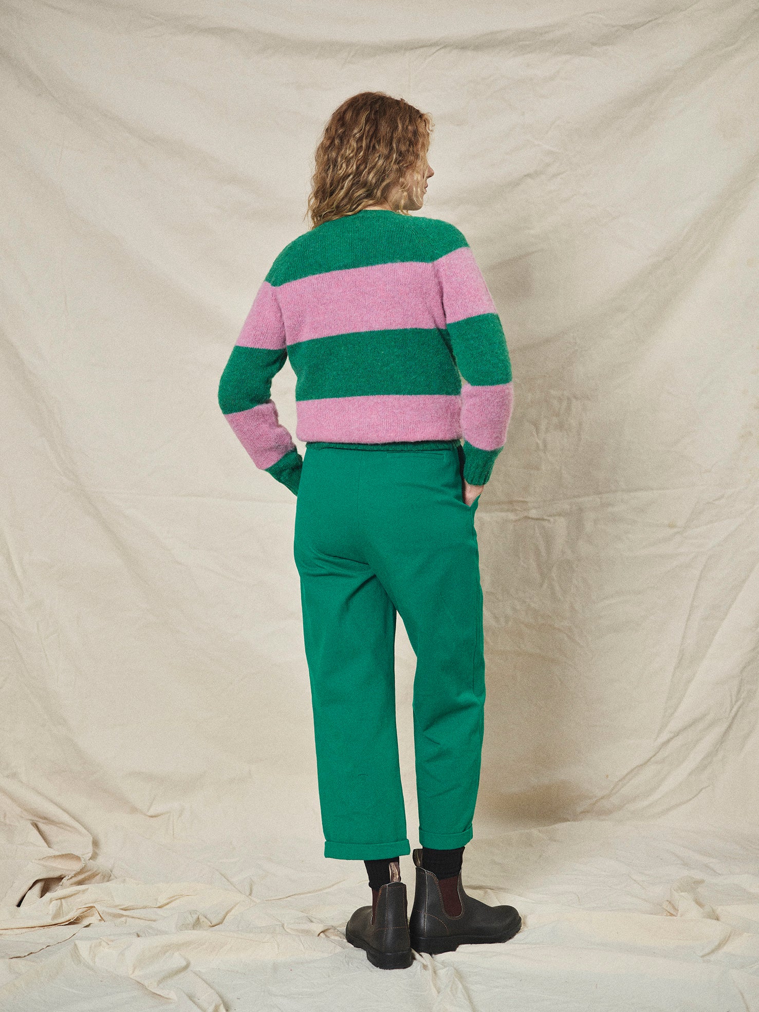A pair of green pleat front trousers with a tab front opening and back jet pockets.