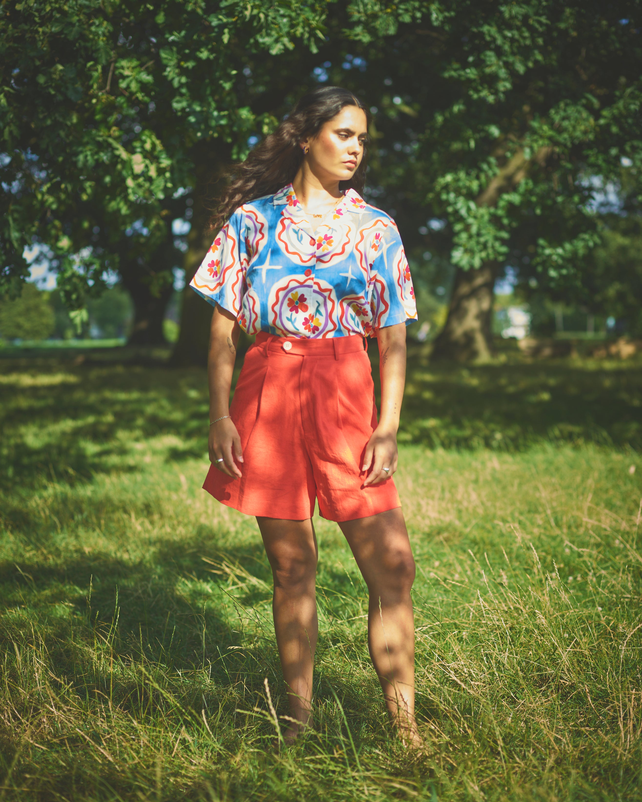A pair of high-waisted, mid-length, tailored tomato shorts made from a cotton and linen mix.