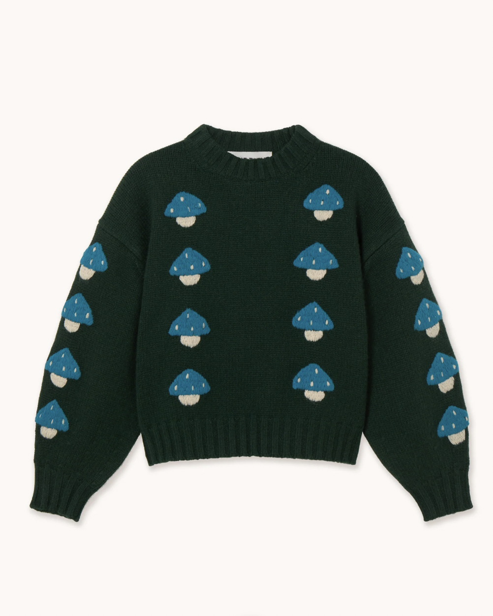 A dark forest green crewneck sweater featuring an all-over pattern of blue and white embroidered mushrooms, laid flat against a light cream background.