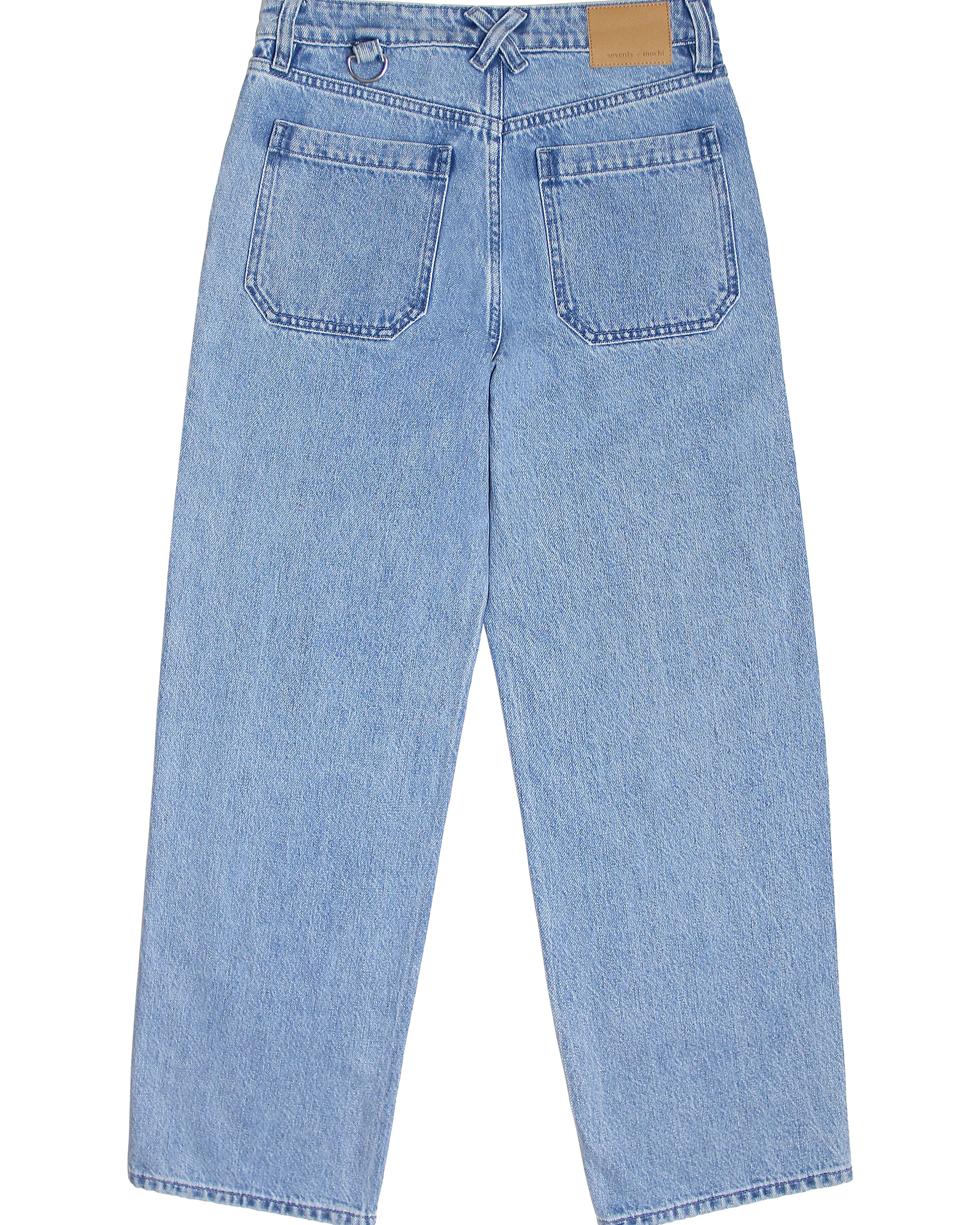 A pair of blue carpenter style jeans with embroidery on the front legs and a center front seam, displayed against a white background.