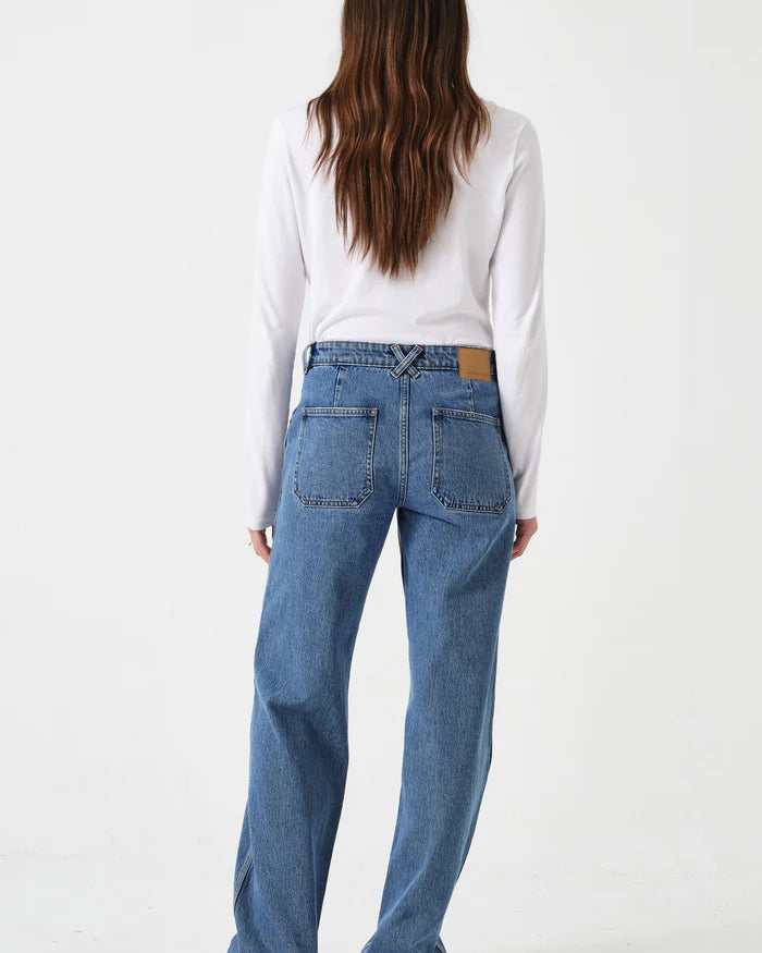 Person wearing blue jeans and a white shirt on a white background