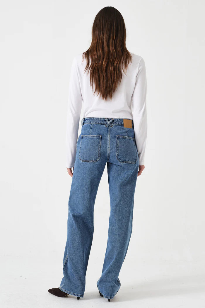 Person wearing blue jeans and a white shirt on a white background