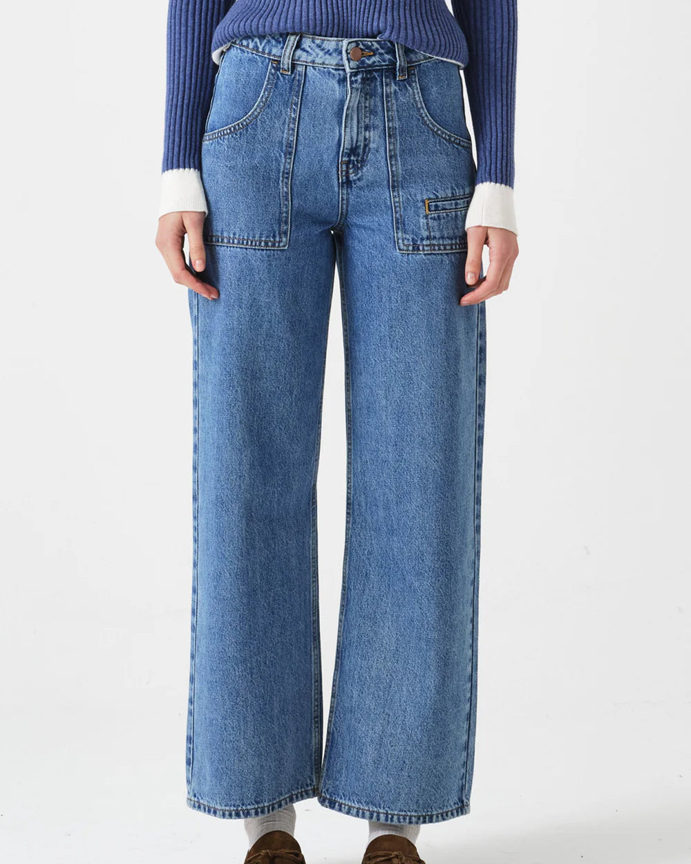 Person wearing blue jeans and a blue sweater on a white background