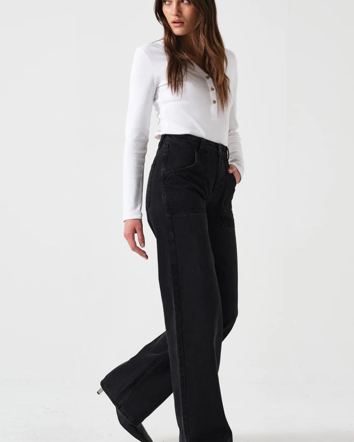 Woman wearing a white blouse and black pants on a white background