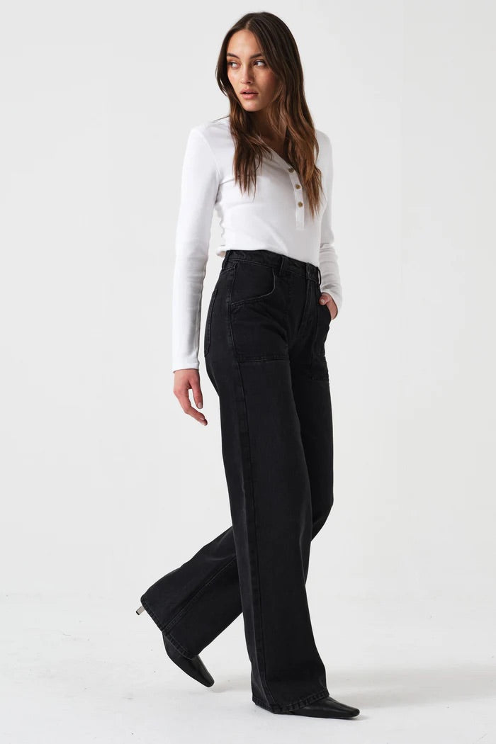 Woman wearing a white blouse and black pants on a white background