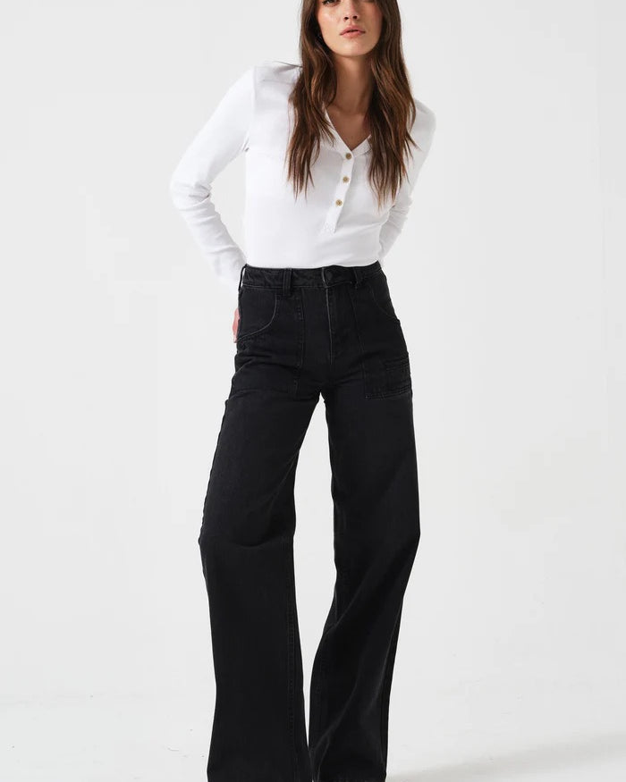 Woman wearing a white blouse and black pants on a white background