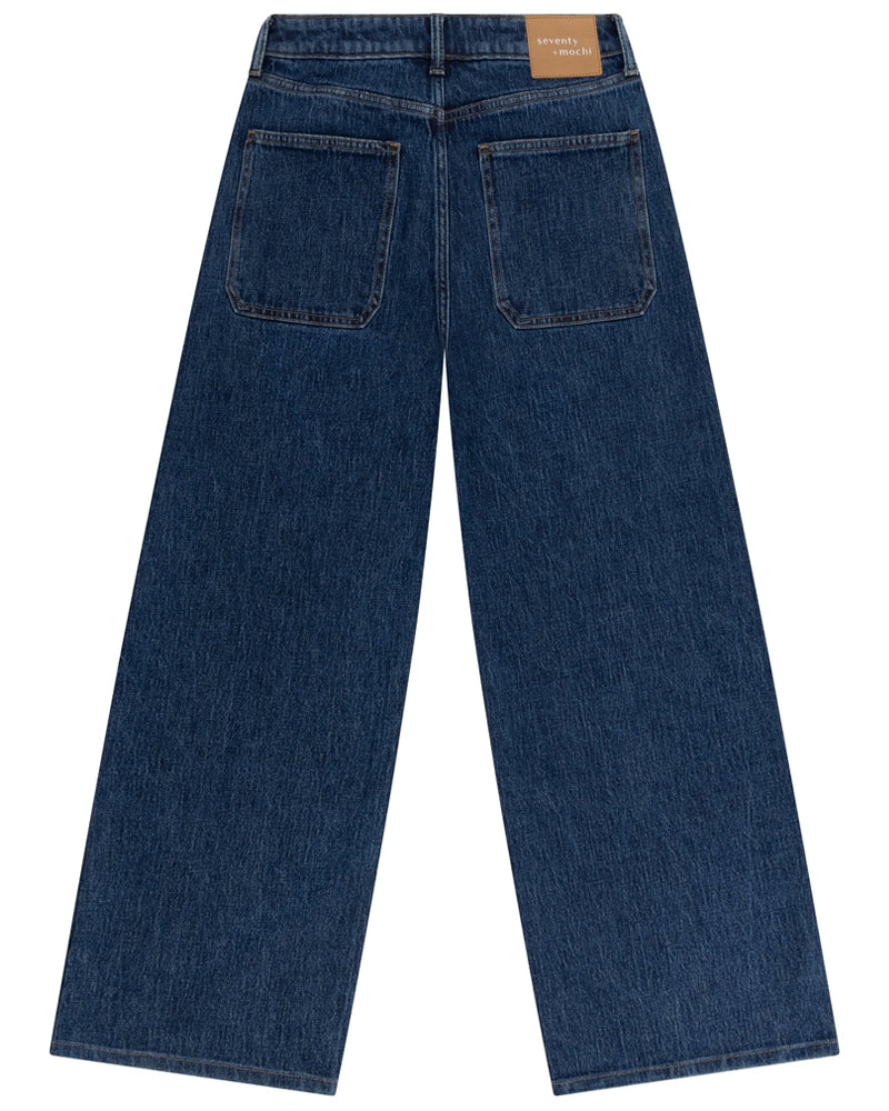 Back view of a pair of blue jeans on a white background