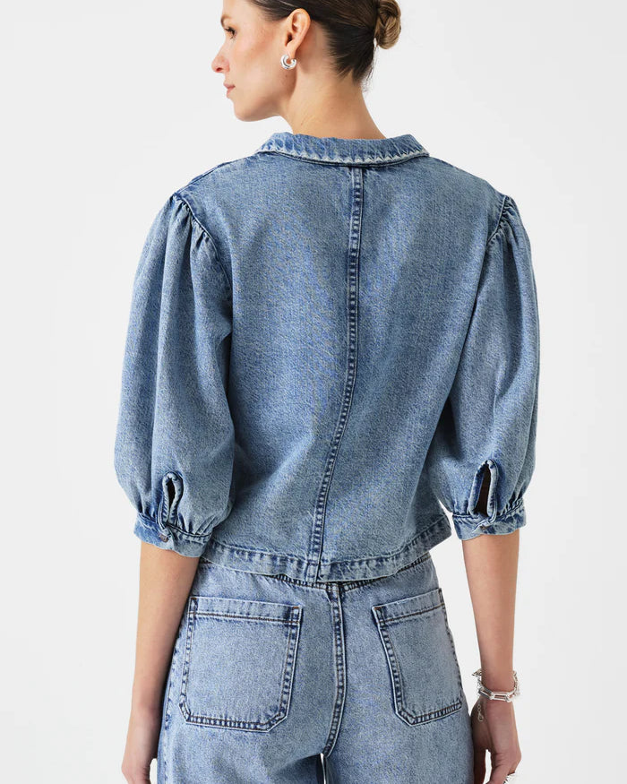 Woman wearing a denim jumpsuit on a white background