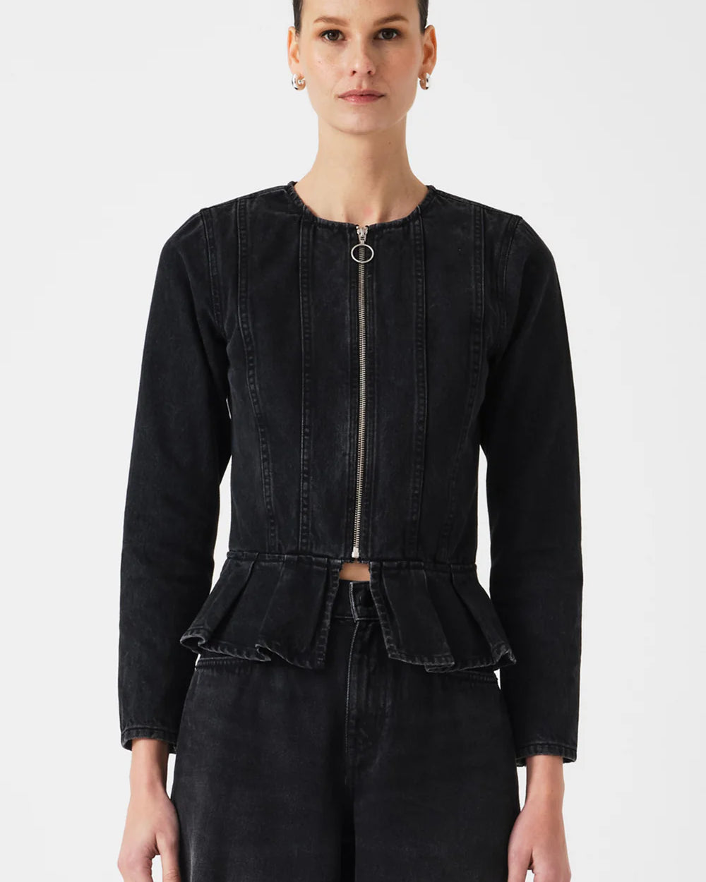 Person wearing a black peplum jacket on a white background