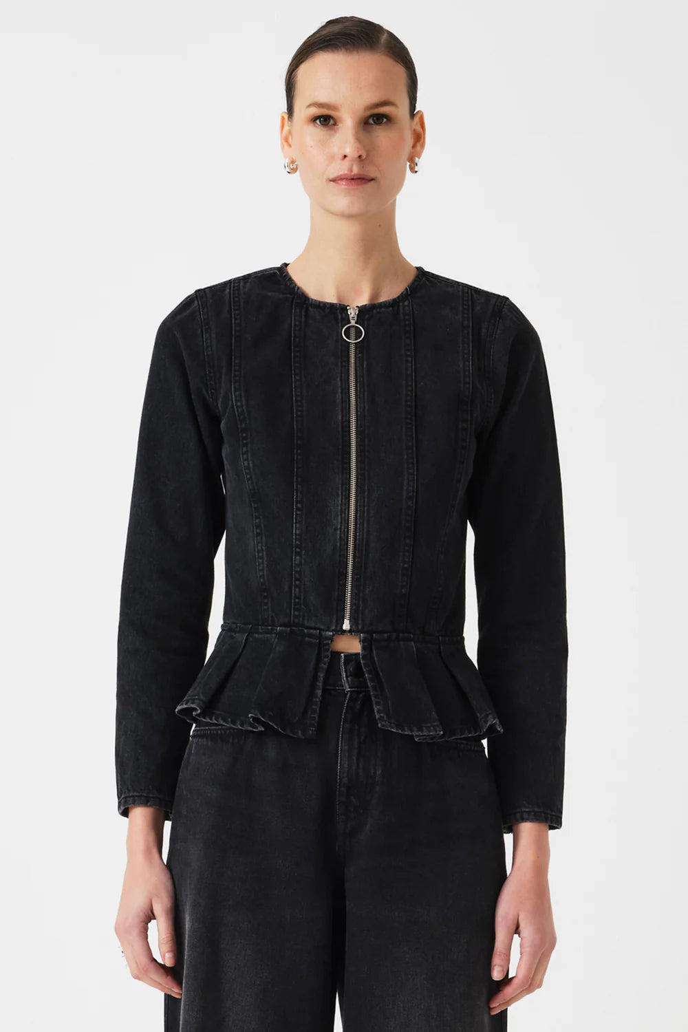 Person wearing a black peplum jacket on a white background