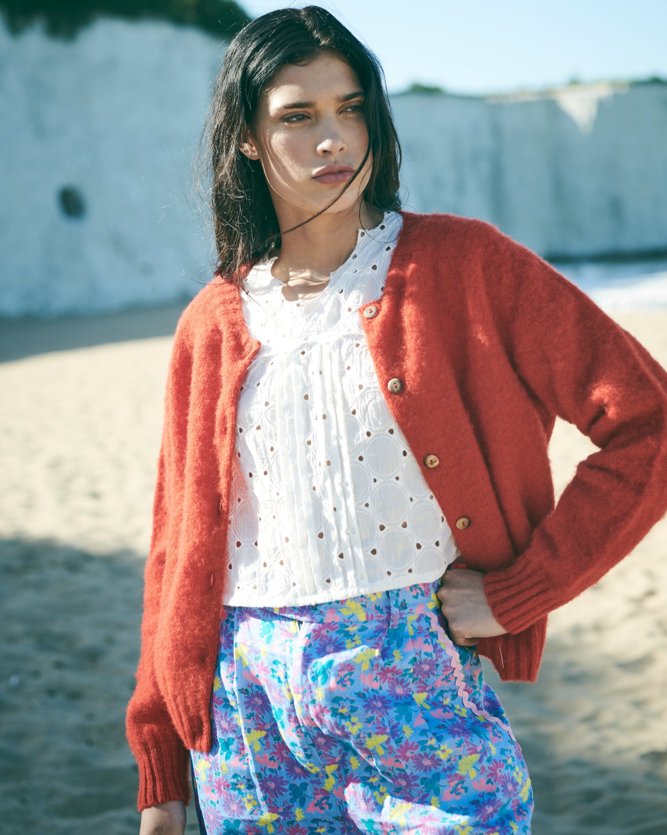 Red cardigan with button details on a white background
