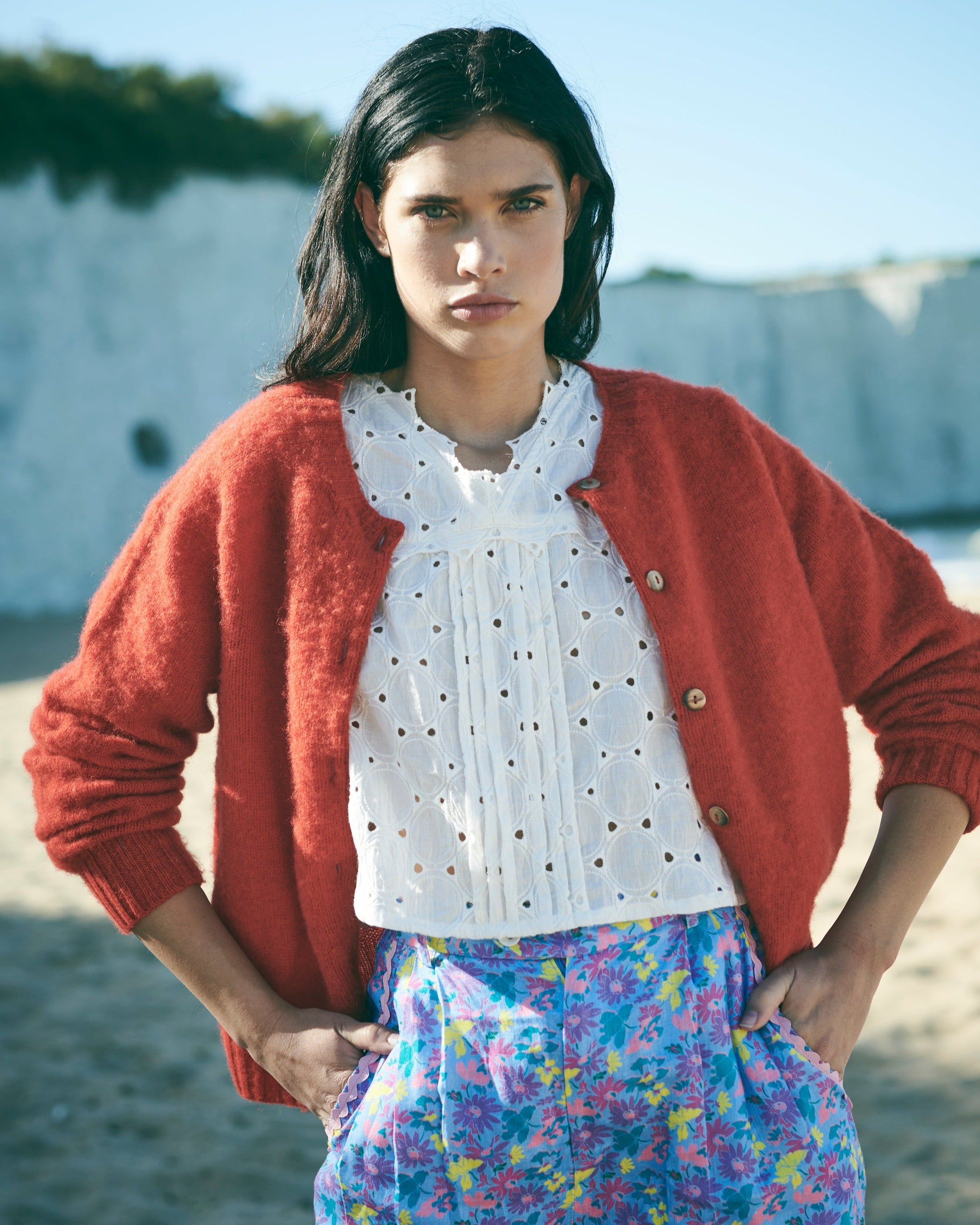 Red cardigan with button details on a white background