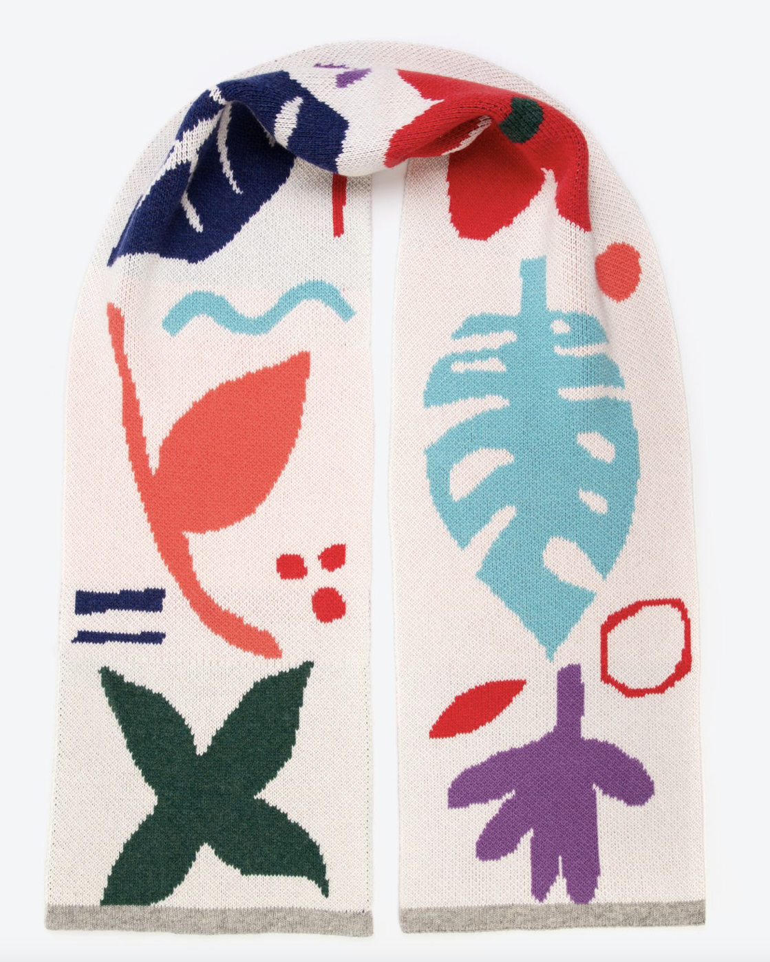 A cream wool scarf with a botanical pattern featuring mismatched shapes in various colors including green, red, blue, purple, pink, and turquoise, finished with a light grey edging.