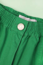 A pair of green cotton workwear style trousers with high elasticated waist and utility style pocket detailing.