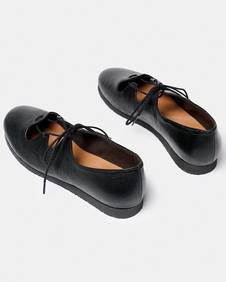 A pair of black leather lace-up shoes with a rounded toe and decorative cutout details on the sides, displayed on a light gray background.