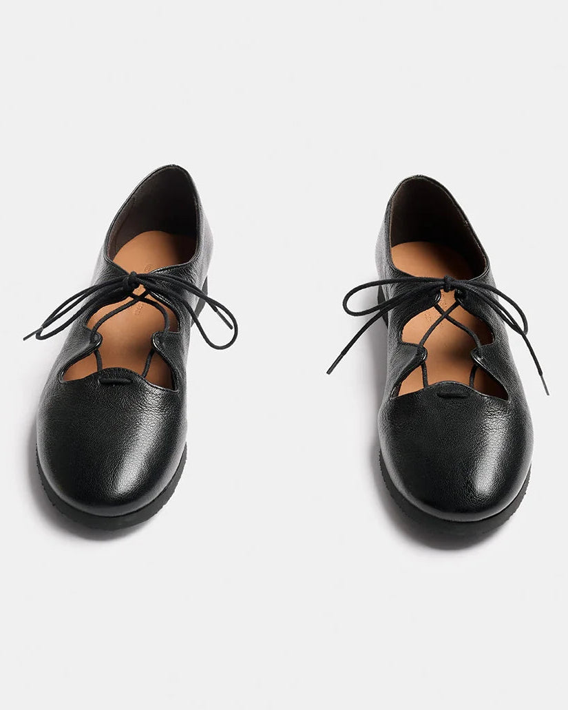 A pair of black leather lace-up shoes with a rounded toe and decorative cutout details, shown from a top-down view on a light gray background.